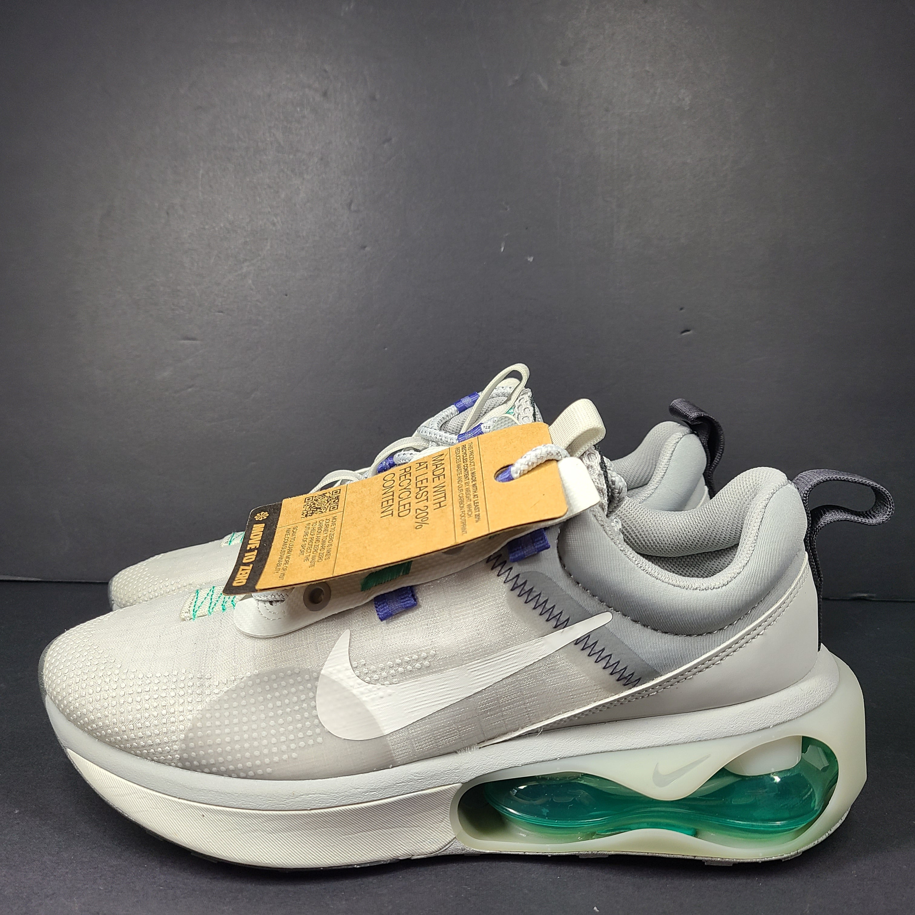 A stylish pair of men's Nike Air Max 2021 sneakers in white, green, and blue.