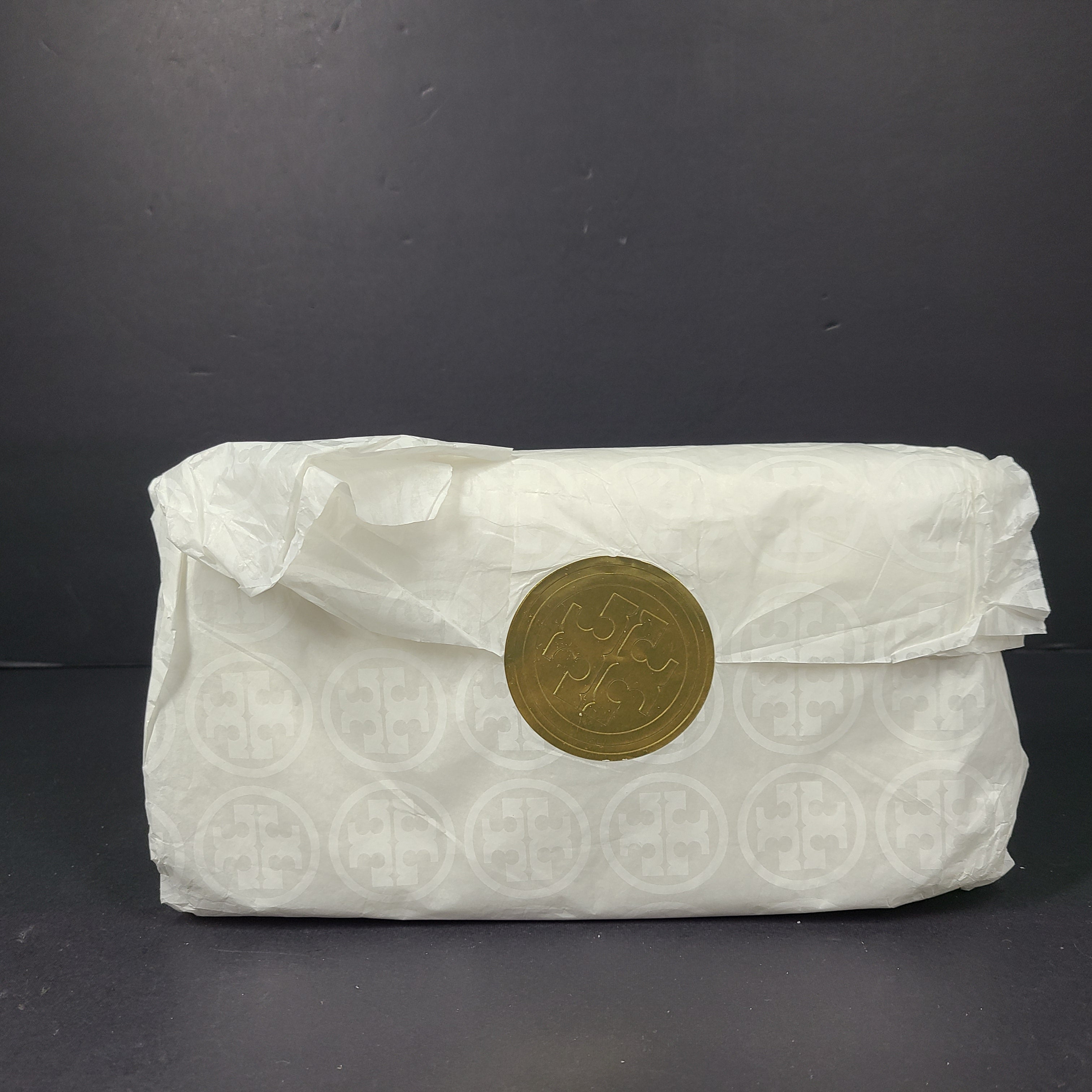 A stylish metallic gold crossbody bag by Tory Burch