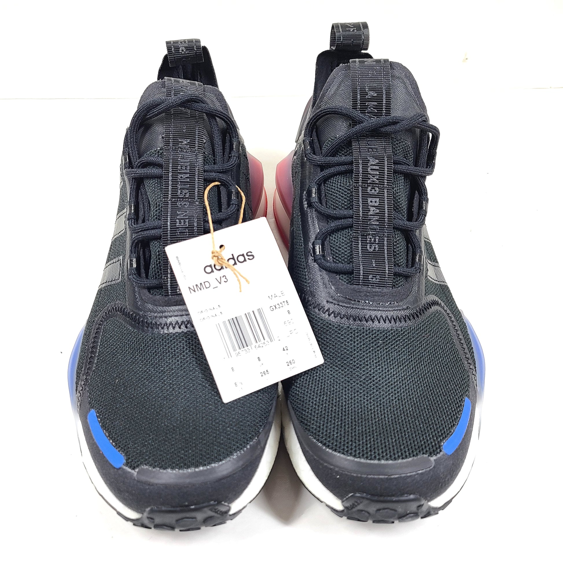 A pair of Adidas NMD_V3 Originals Shoes in black, gold, and white color scheme