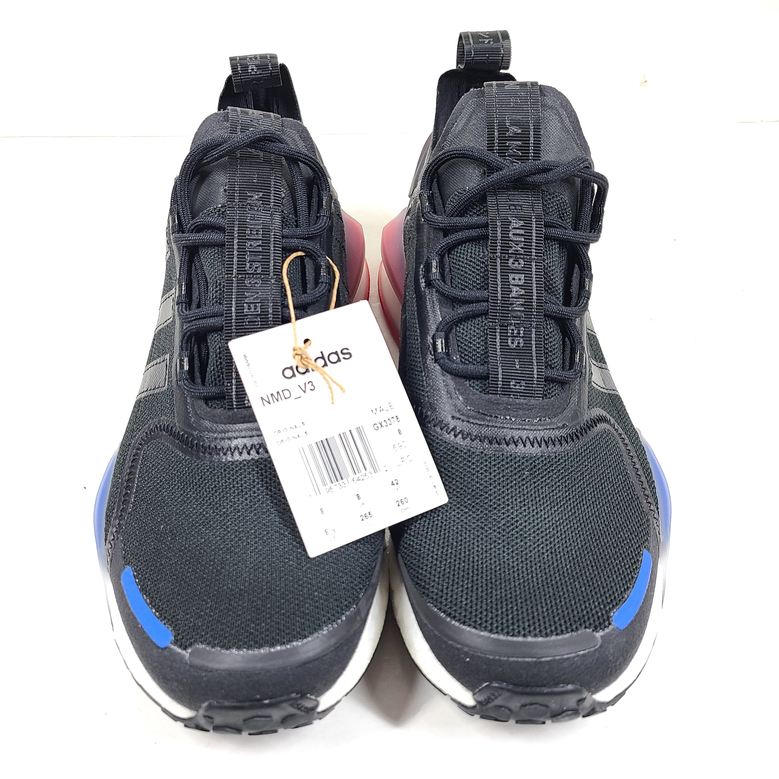 A pair of Adidas NMD_V3 Originals Shoes in black, gold, and white color scheme