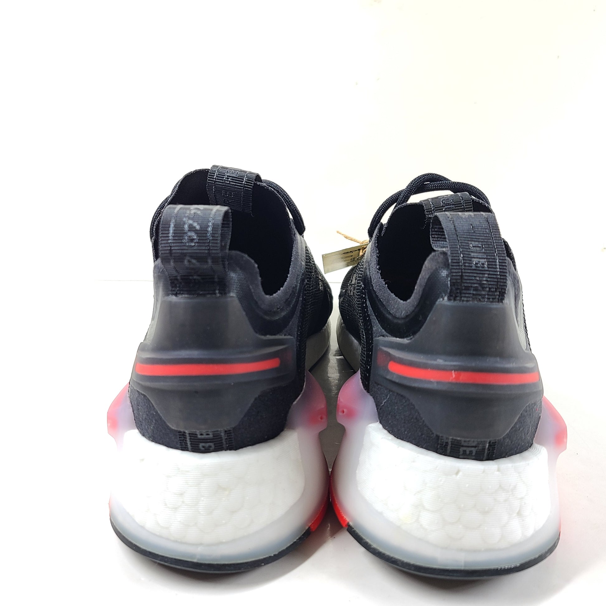 A pair of Adidas NMD_V3 Originals Shoes in black, gold, and white color scheme