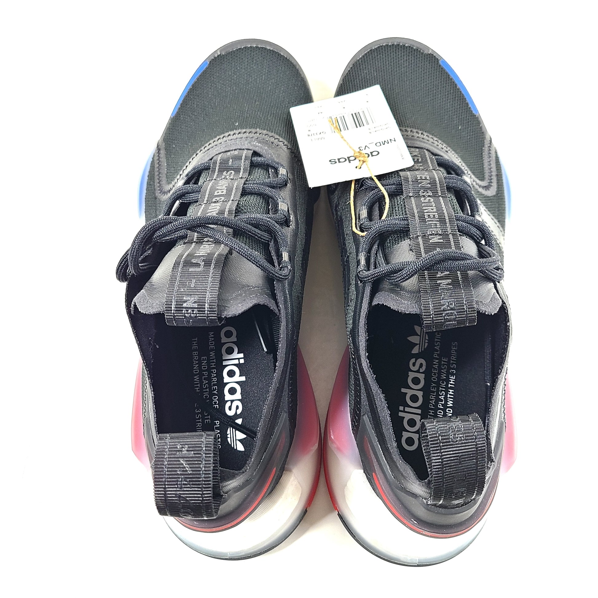 A pair of Adidas NMD_V3 Originals Shoes in black, gold, and white color scheme