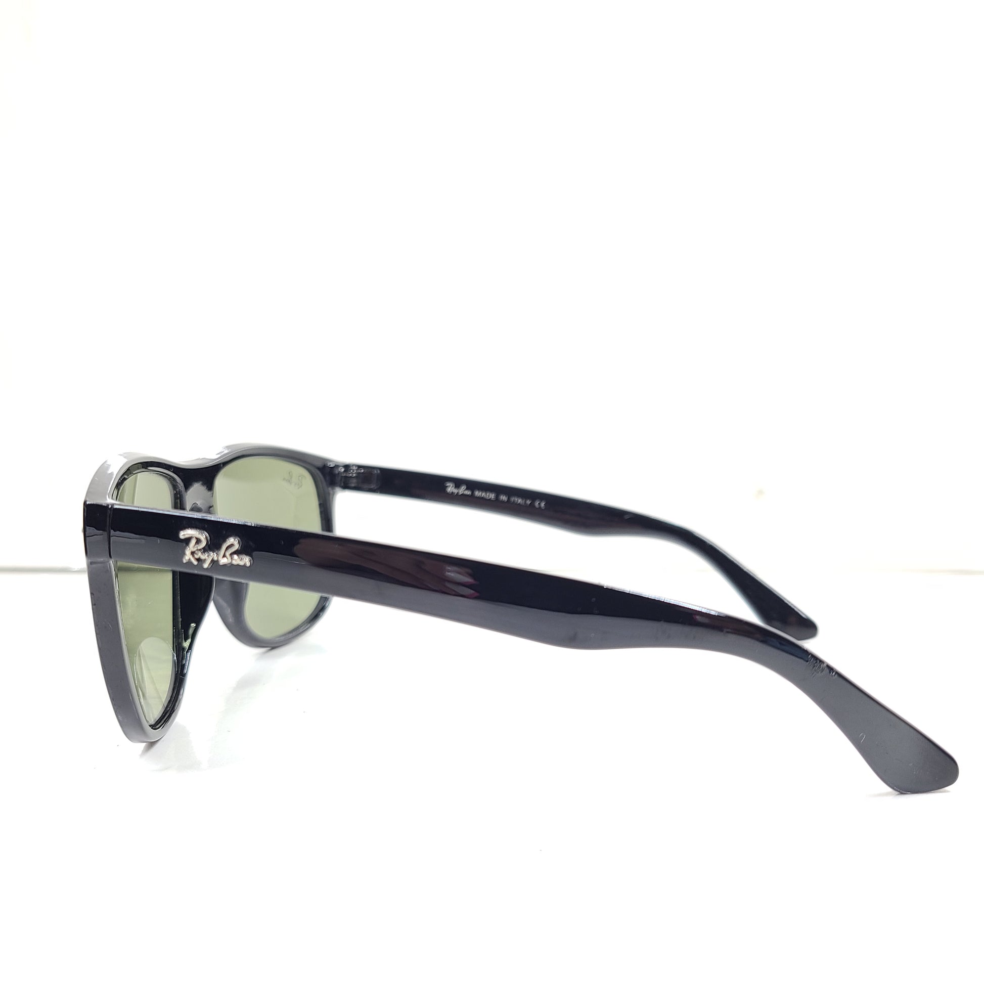 A pair of pre-owned black frame Ray-Ban sunglasses with green lenses for men