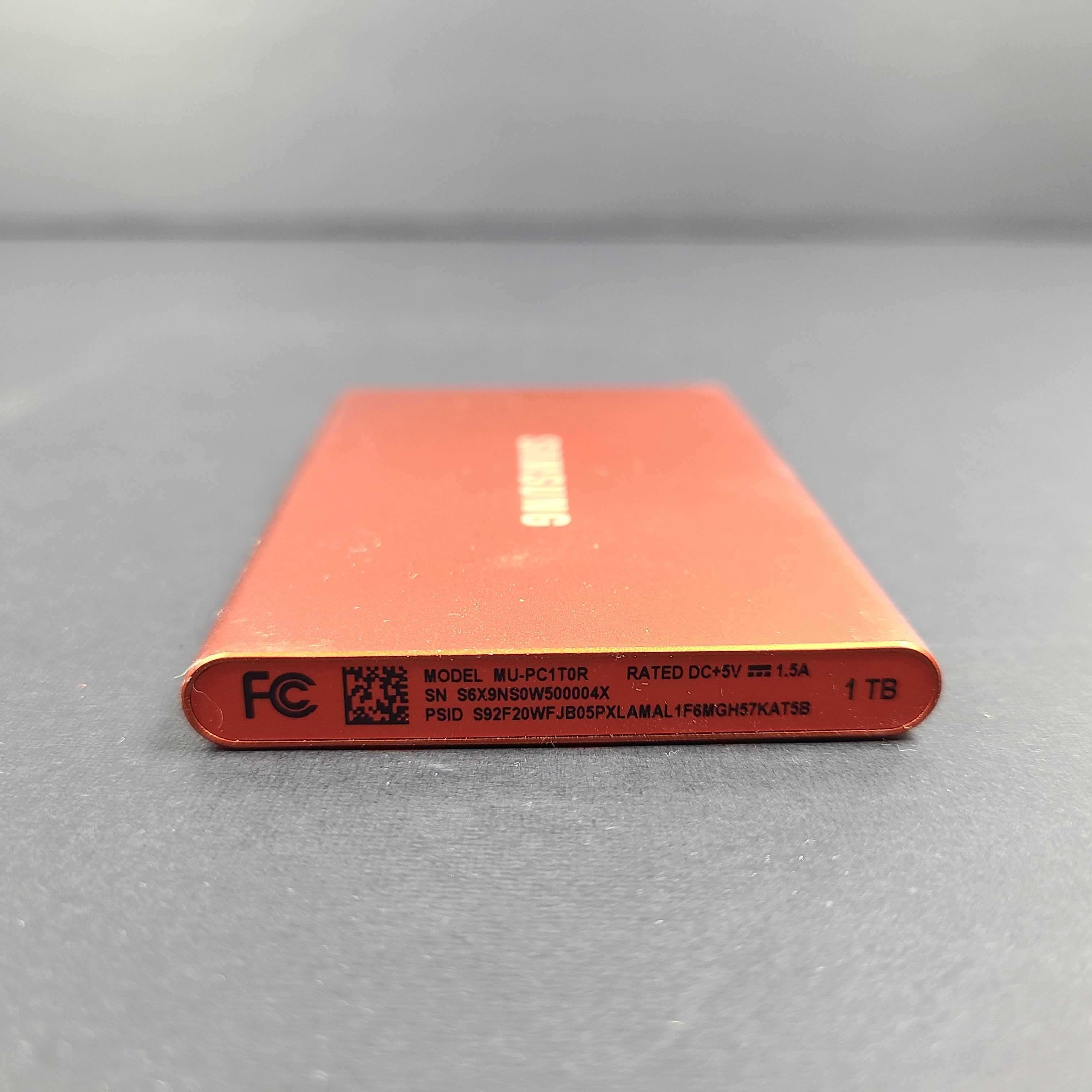A sleek Samsung Portable SSD T7 in bold red color.