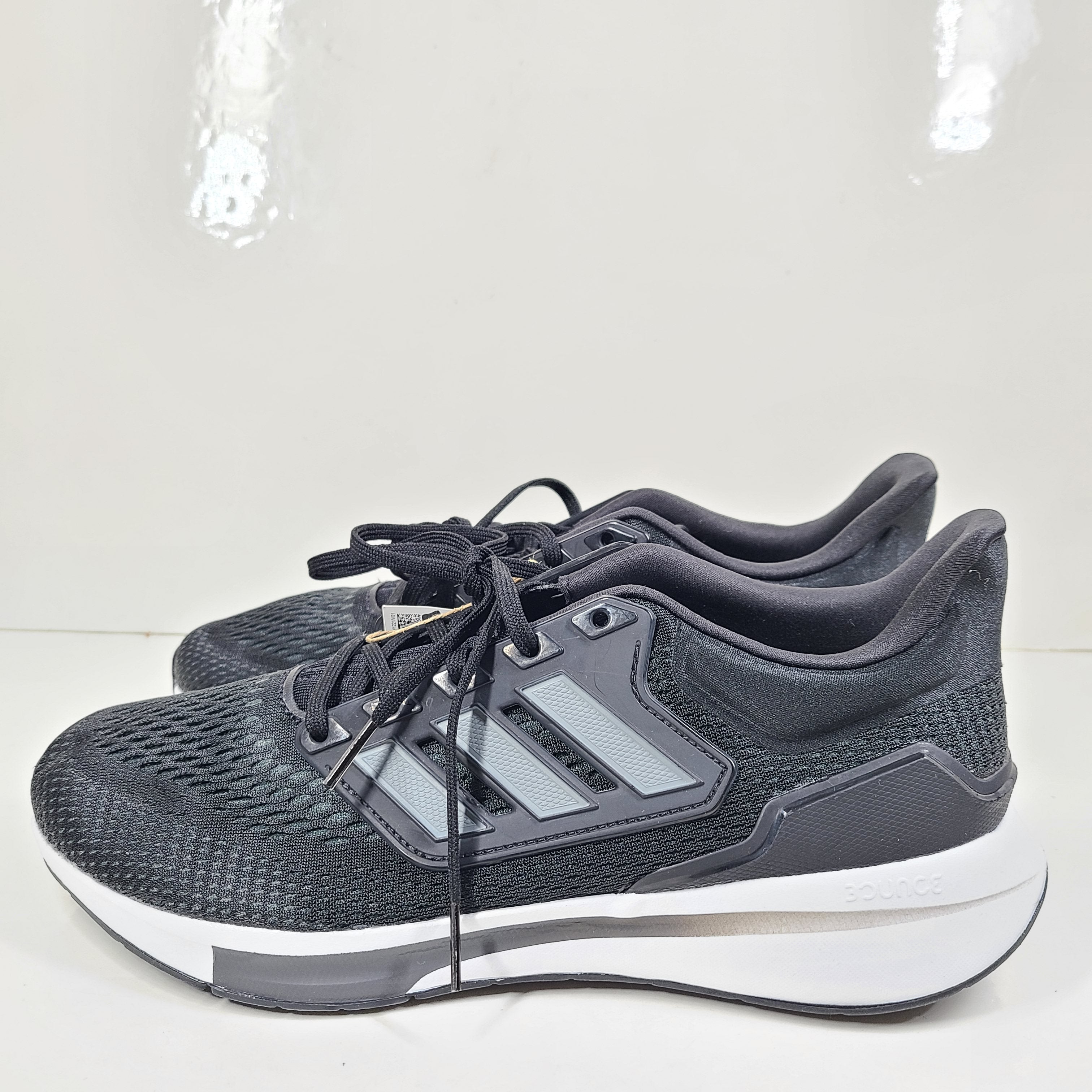 A pair of Adidas EQ21 men's black running shoes.