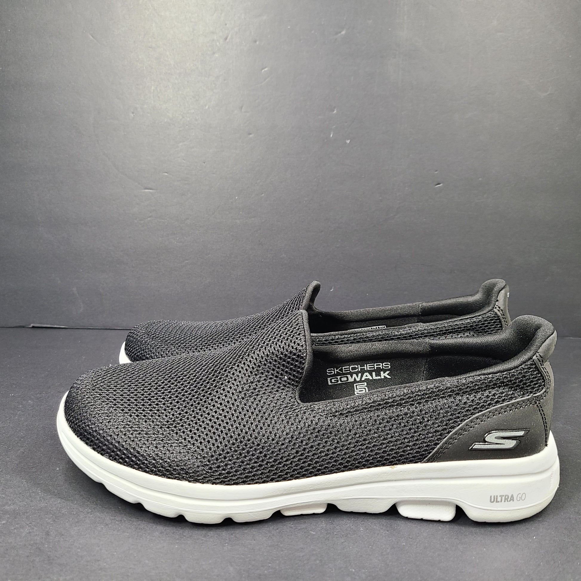 A pair of comfortable Skechers Go Walk 5 Slip-On Shoes in black, size 9.