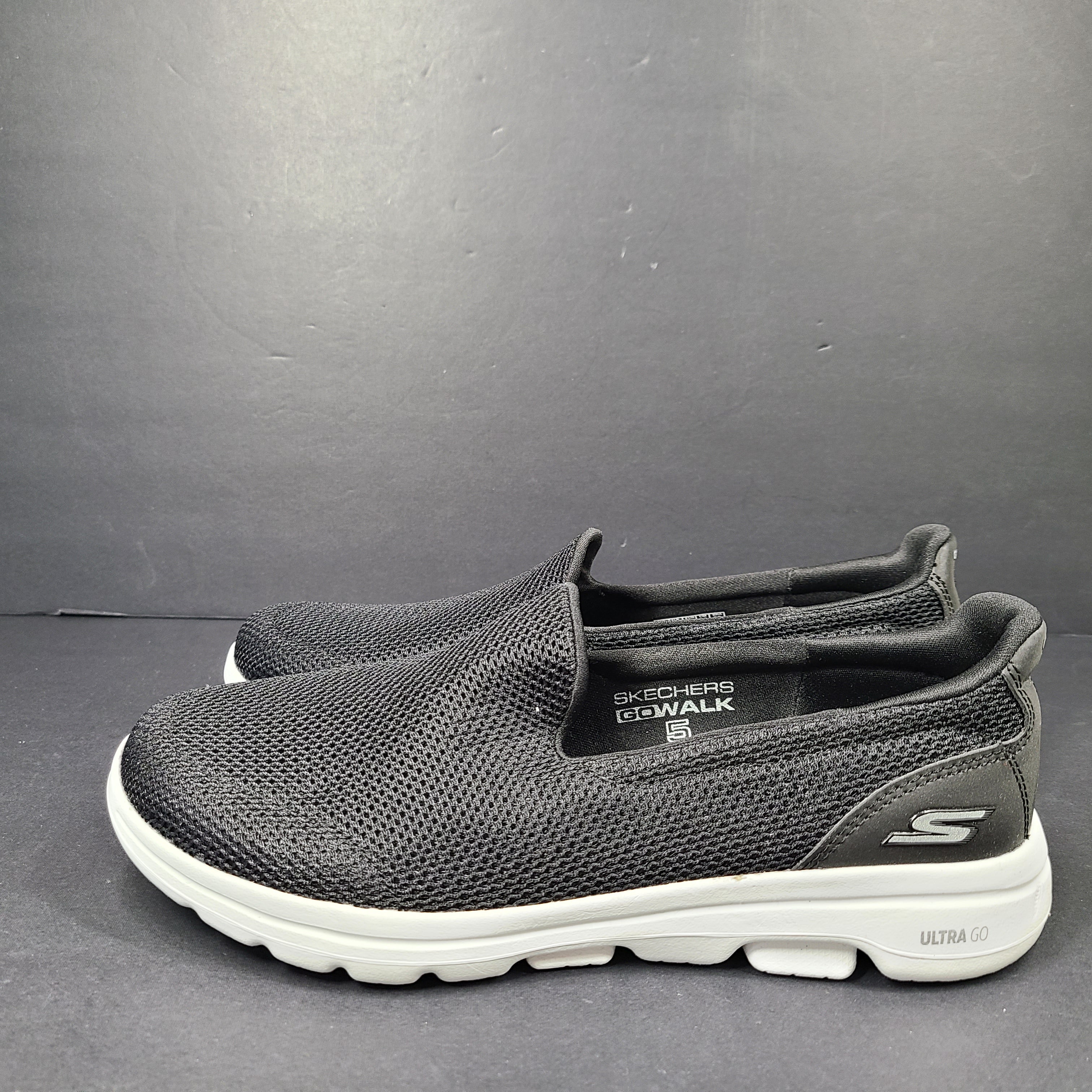 A pair of comfortable Skechers Go Walk 5 Slip-On Shoes in black, size 9.