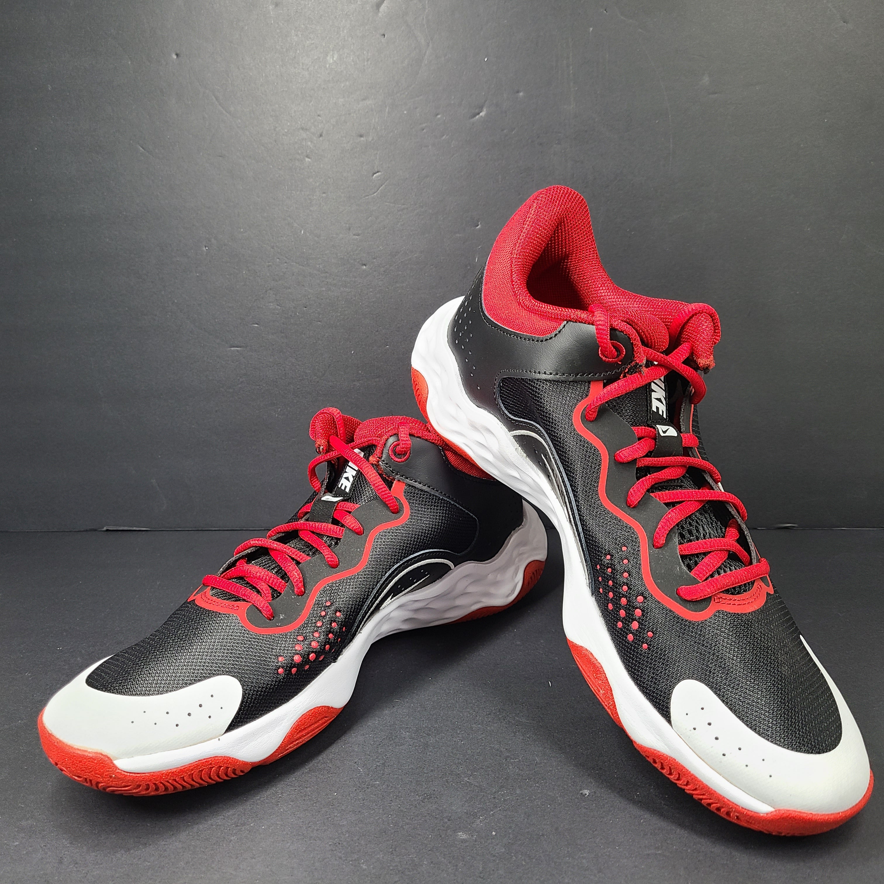 A pair of Nike men’s athletic shoes in black, red, and white.