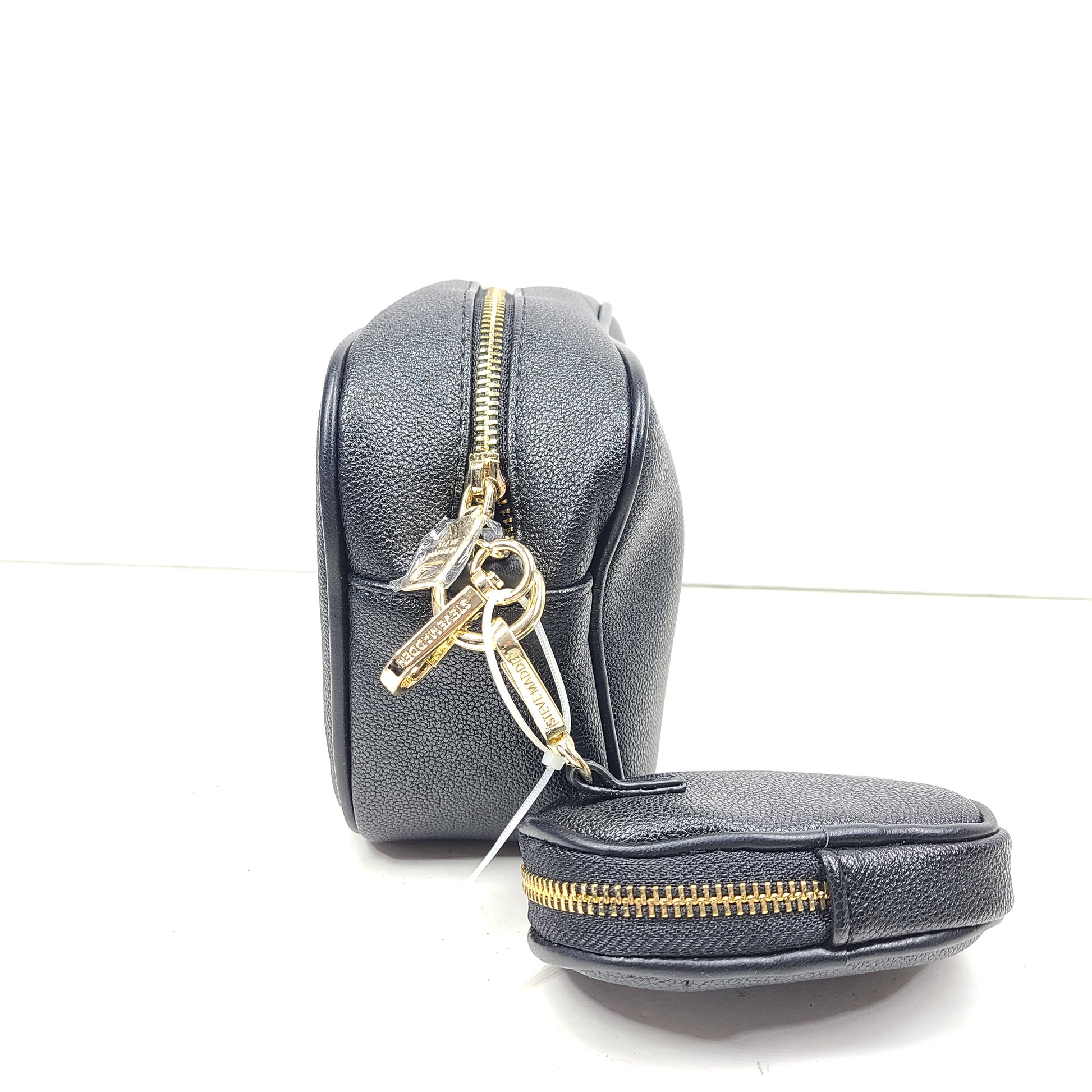 A stylish black crossbody bag with a detachable pouch and gold chain strap.