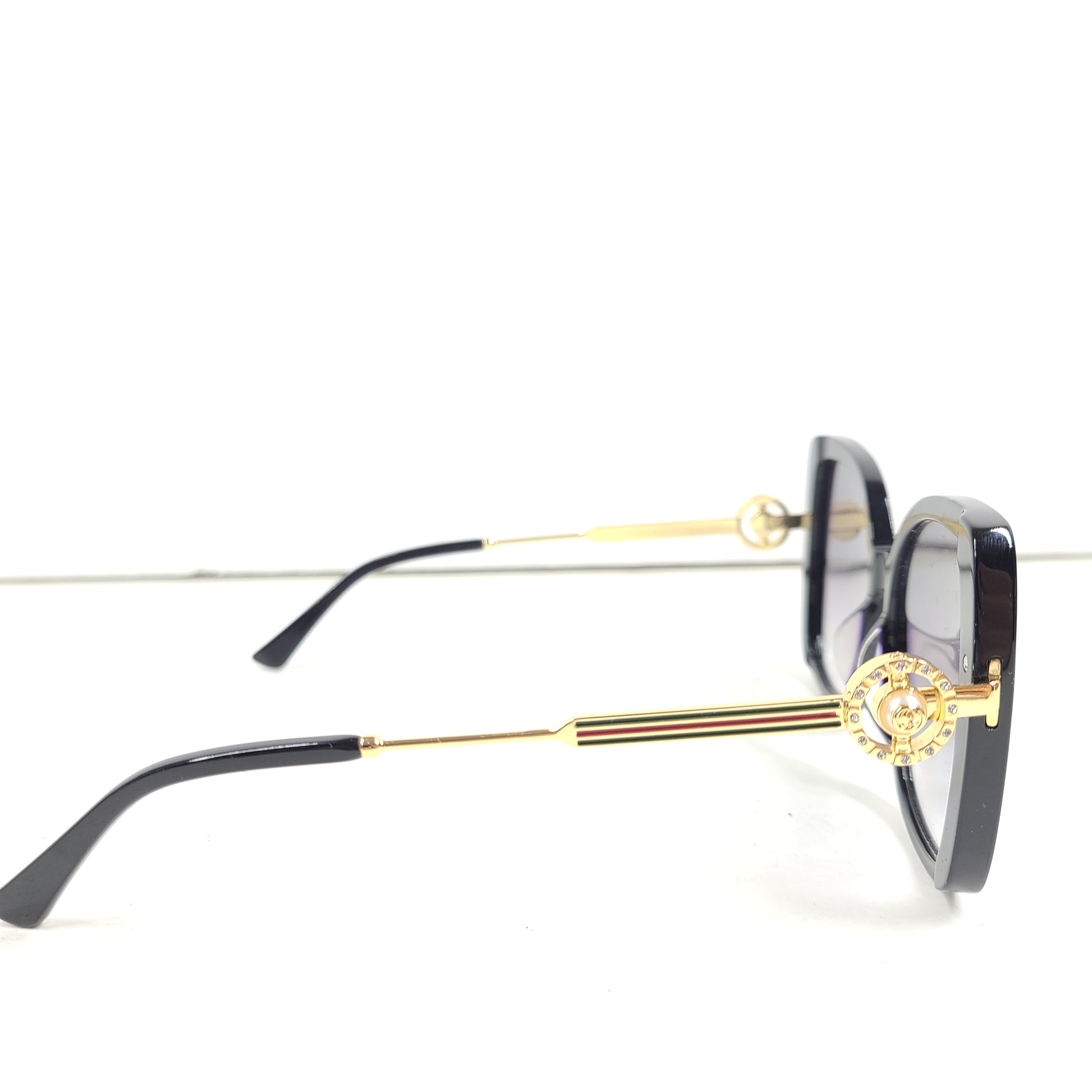 A stylish pair of Gucci women's sunglasses in black and gold gradient.