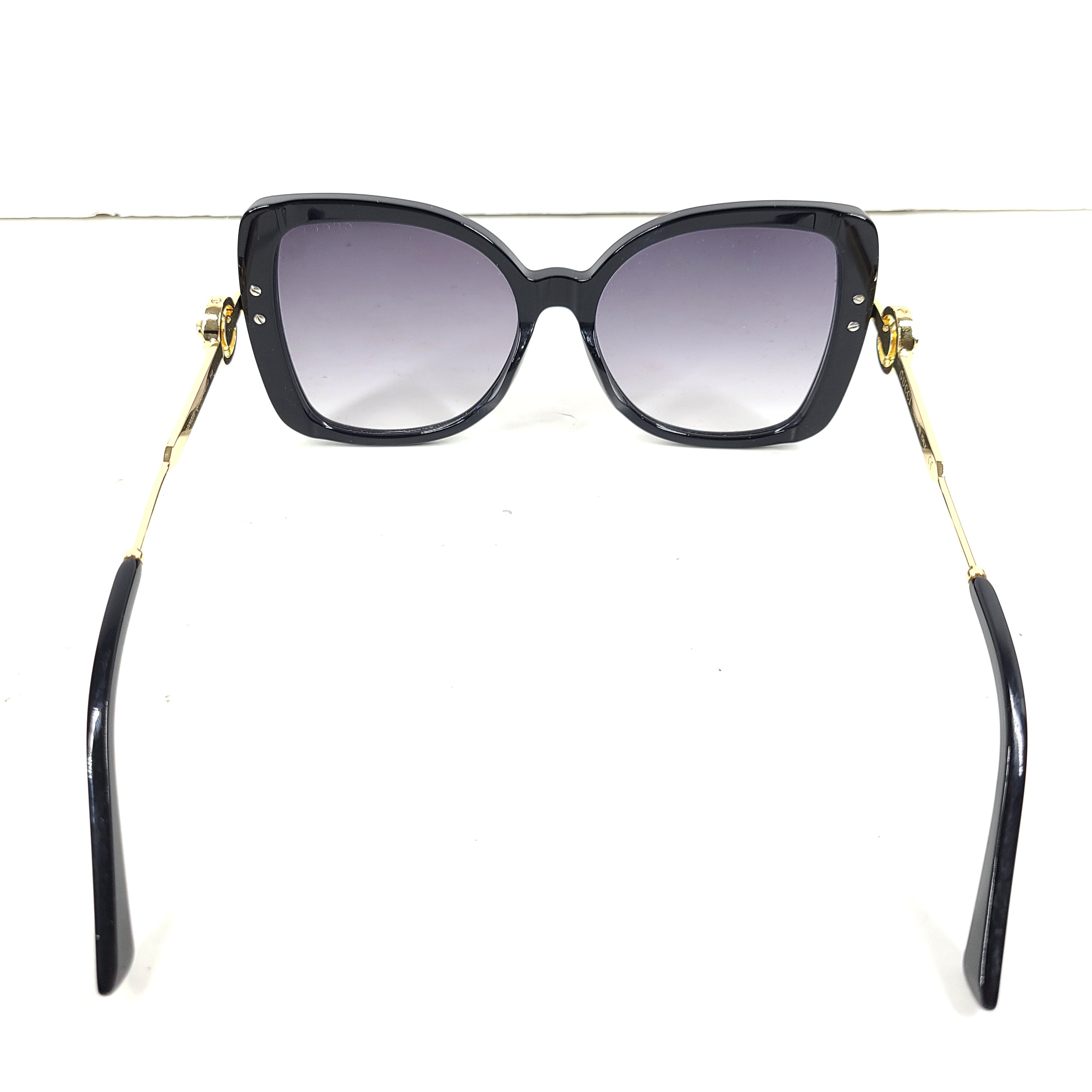 A stylish pair of Gucci women's sunglasses in black and gold gradient.