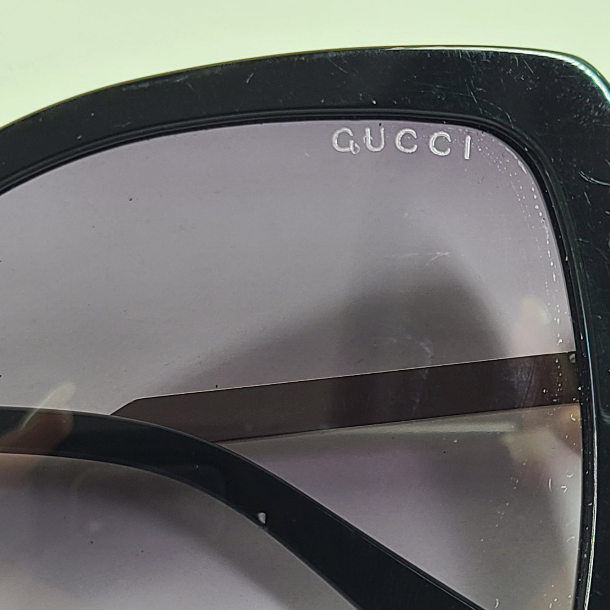 A stylish pair of Gucci women's sunglasses in black and gold gradient.