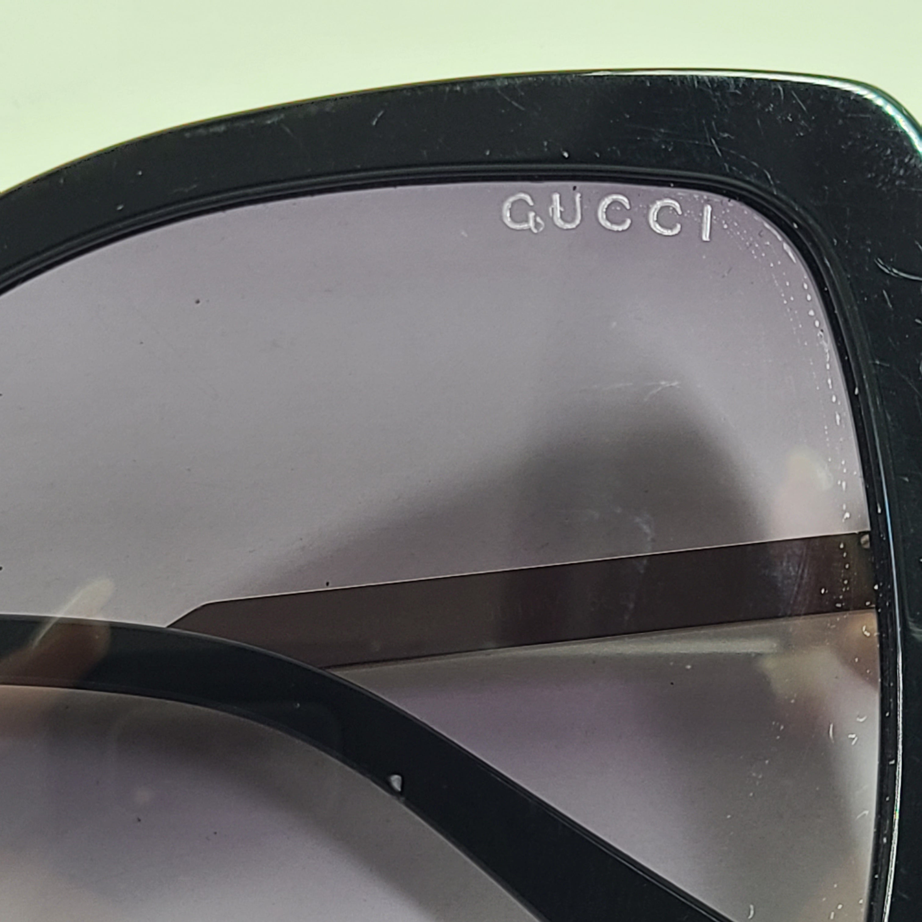 A stylish pair of Gucci women's sunglasses in black and gold gradient.