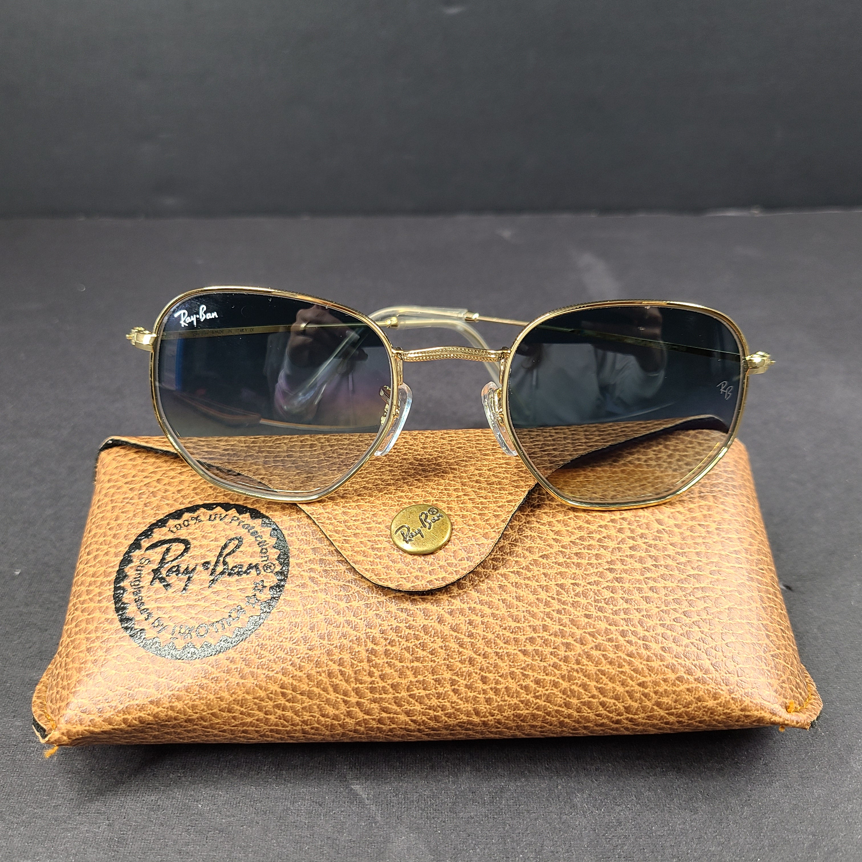 Fashionable Ray-Ban RB3548 Hexagonal Sunglasses with gold frames and blue lenses.