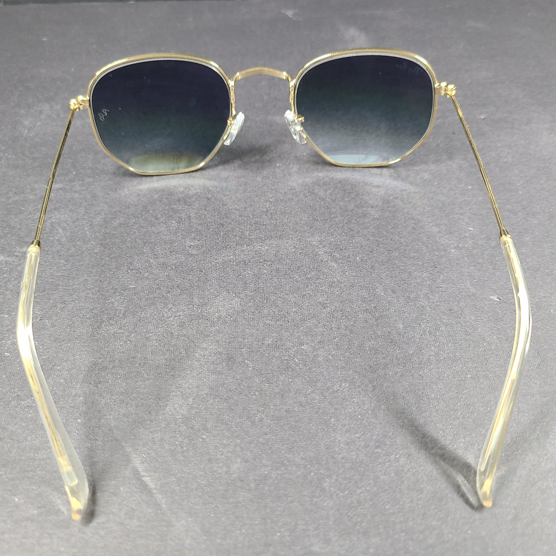 Fashionable Ray-Ban RB3548 Hexagonal Sunglasses with gold frames and blue lenses.