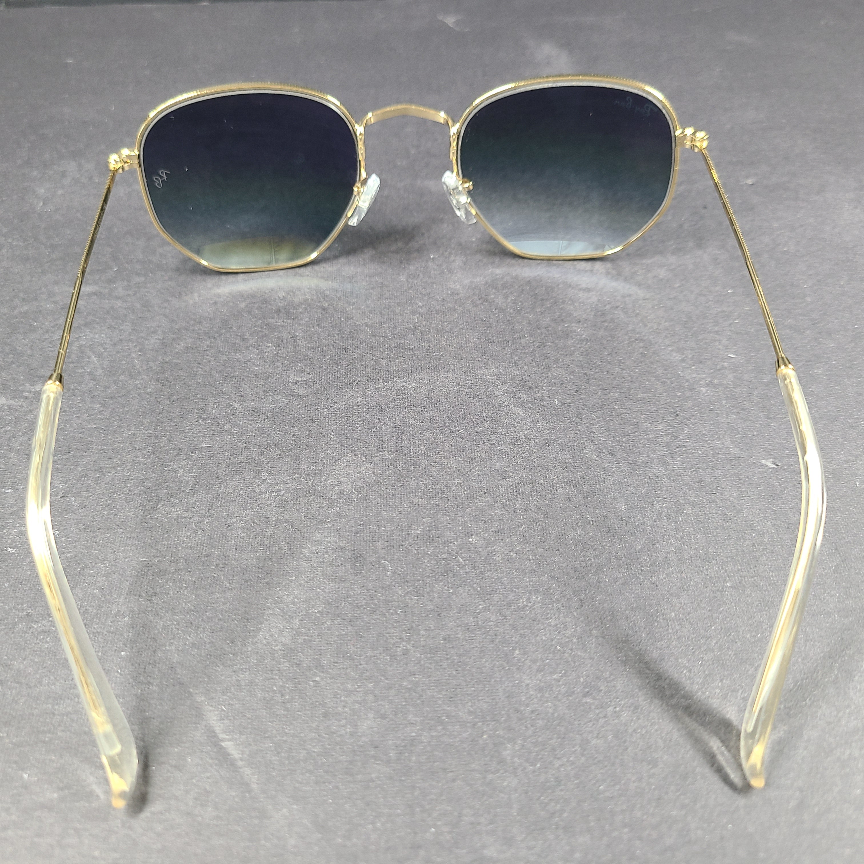 Fashionable Ray-Ban RB3548 Hexagonal Sunglasses with gold frames and blue lenses.