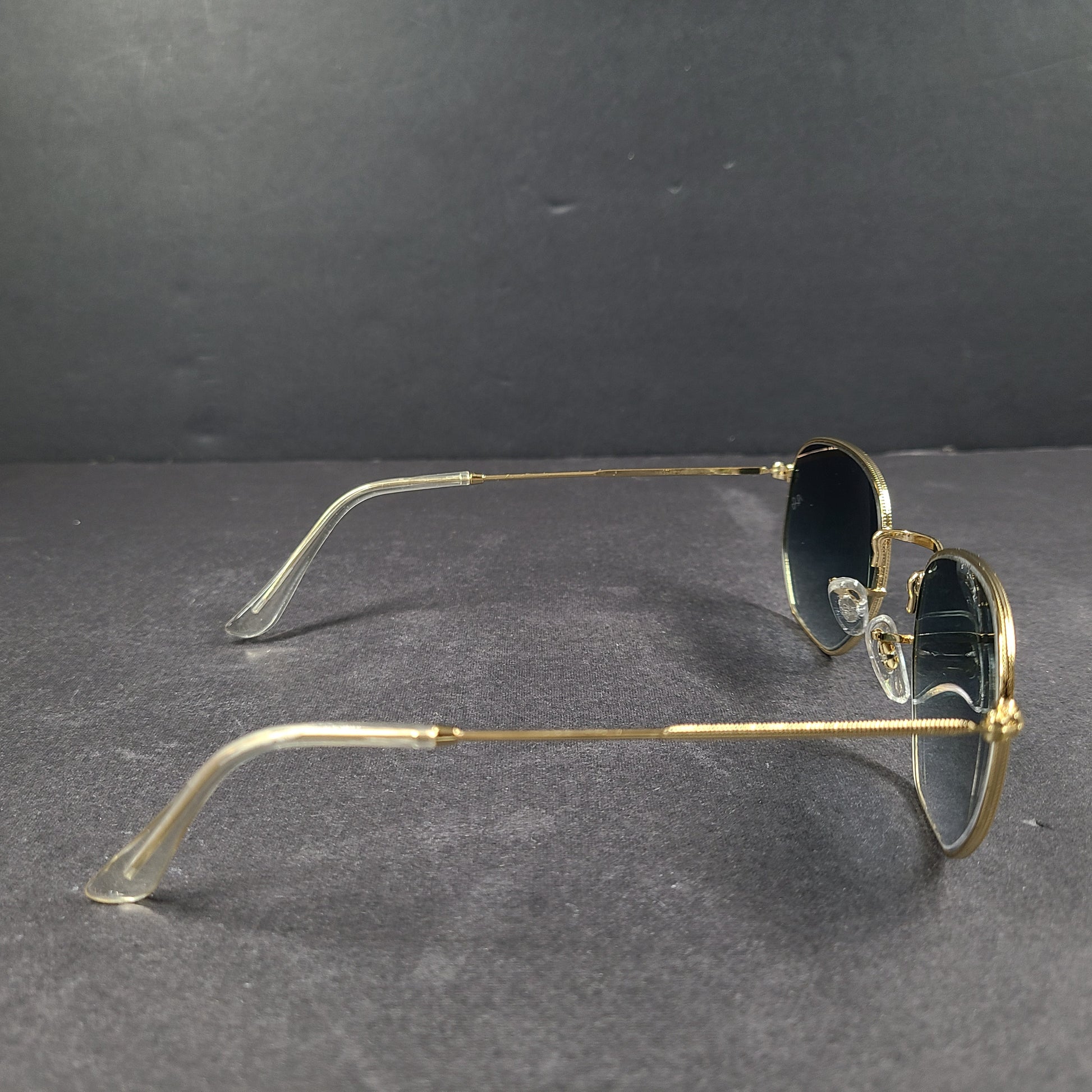 Fashionable Ray-Ban RB3548 Hexagonal Sunglasses with gold frames and blue lenses.