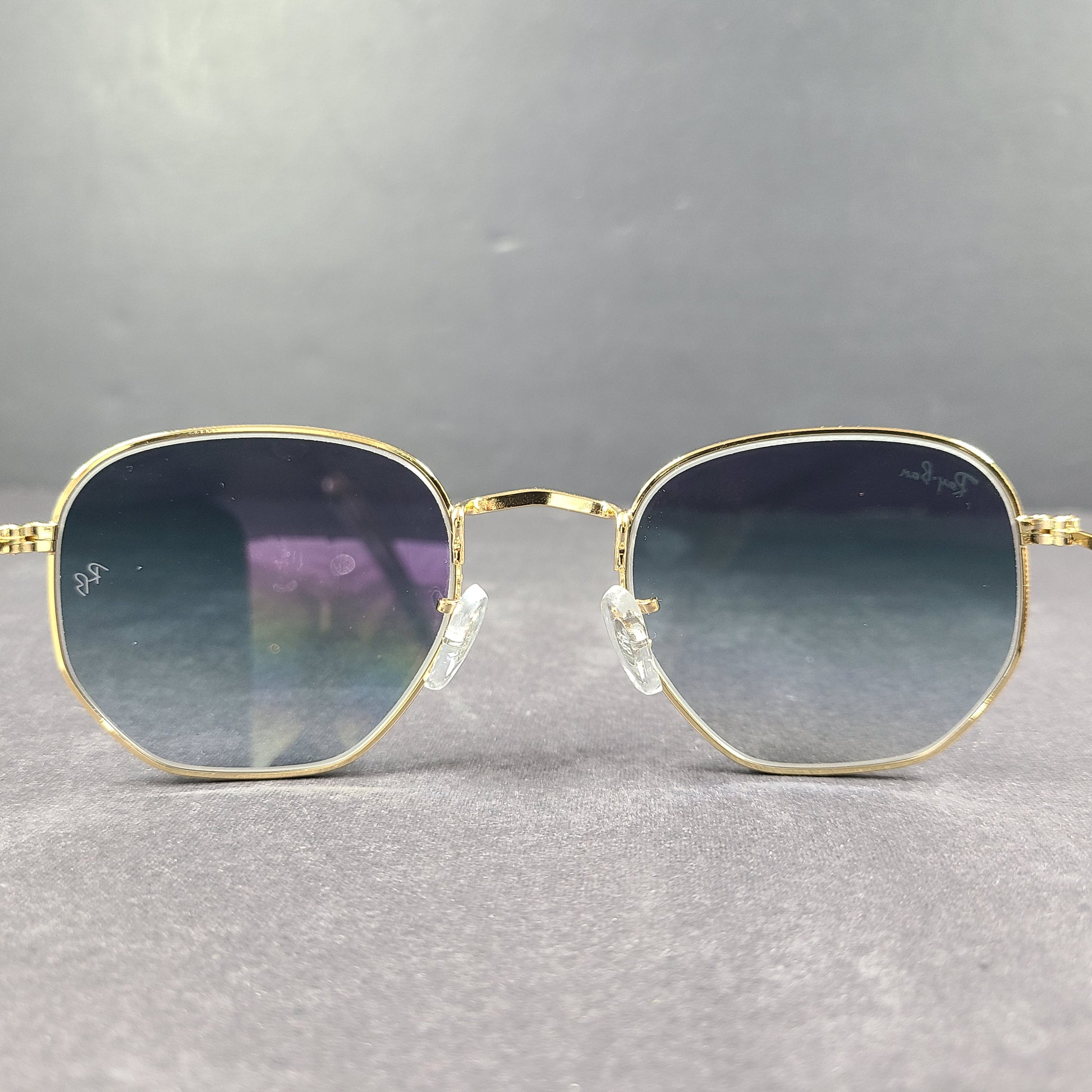 Fashionable Ray-Ban RB3548 Hexagonal Sunglasses with gold frames and blue lenses.