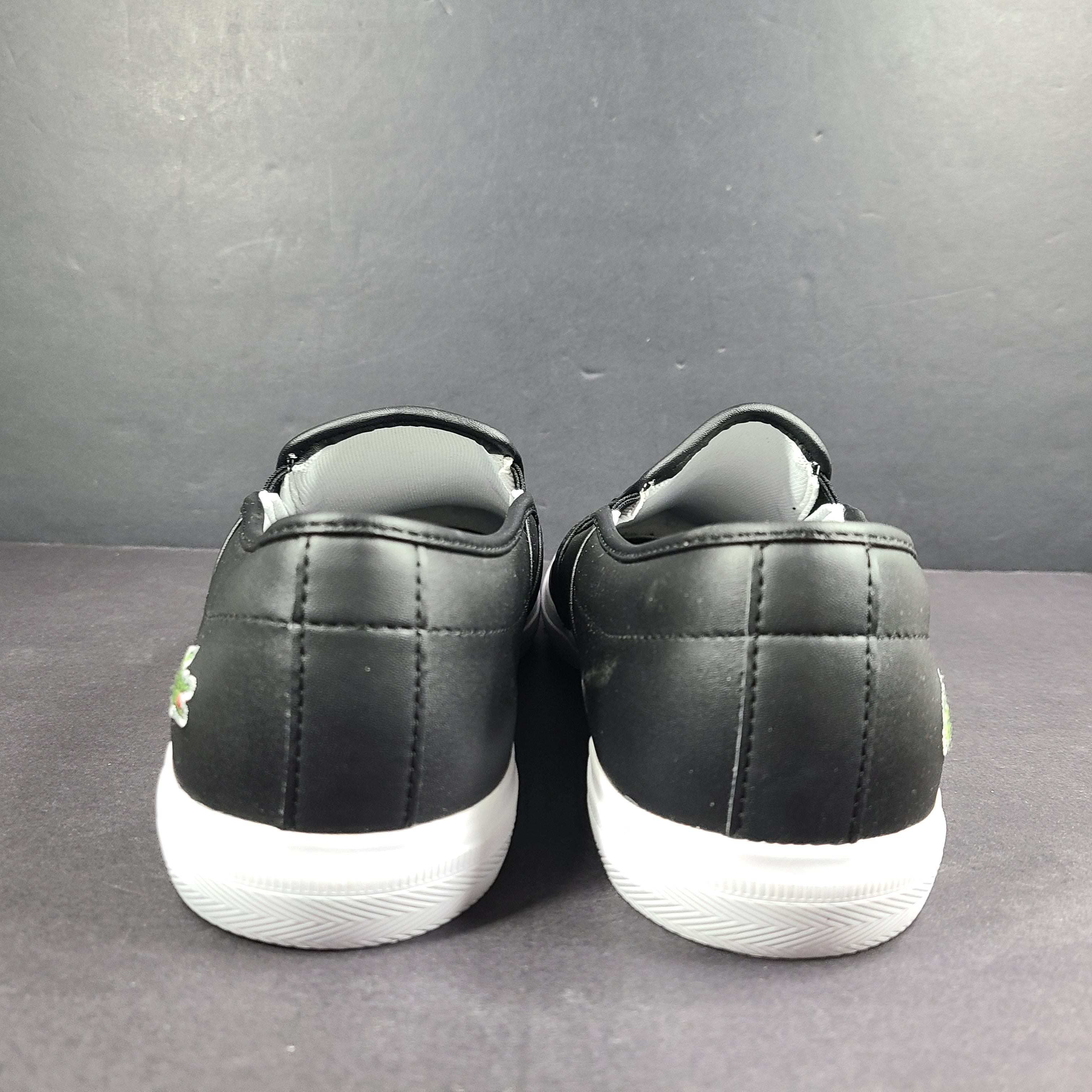A pair of leather slip-on sneakers by Lacoste.
