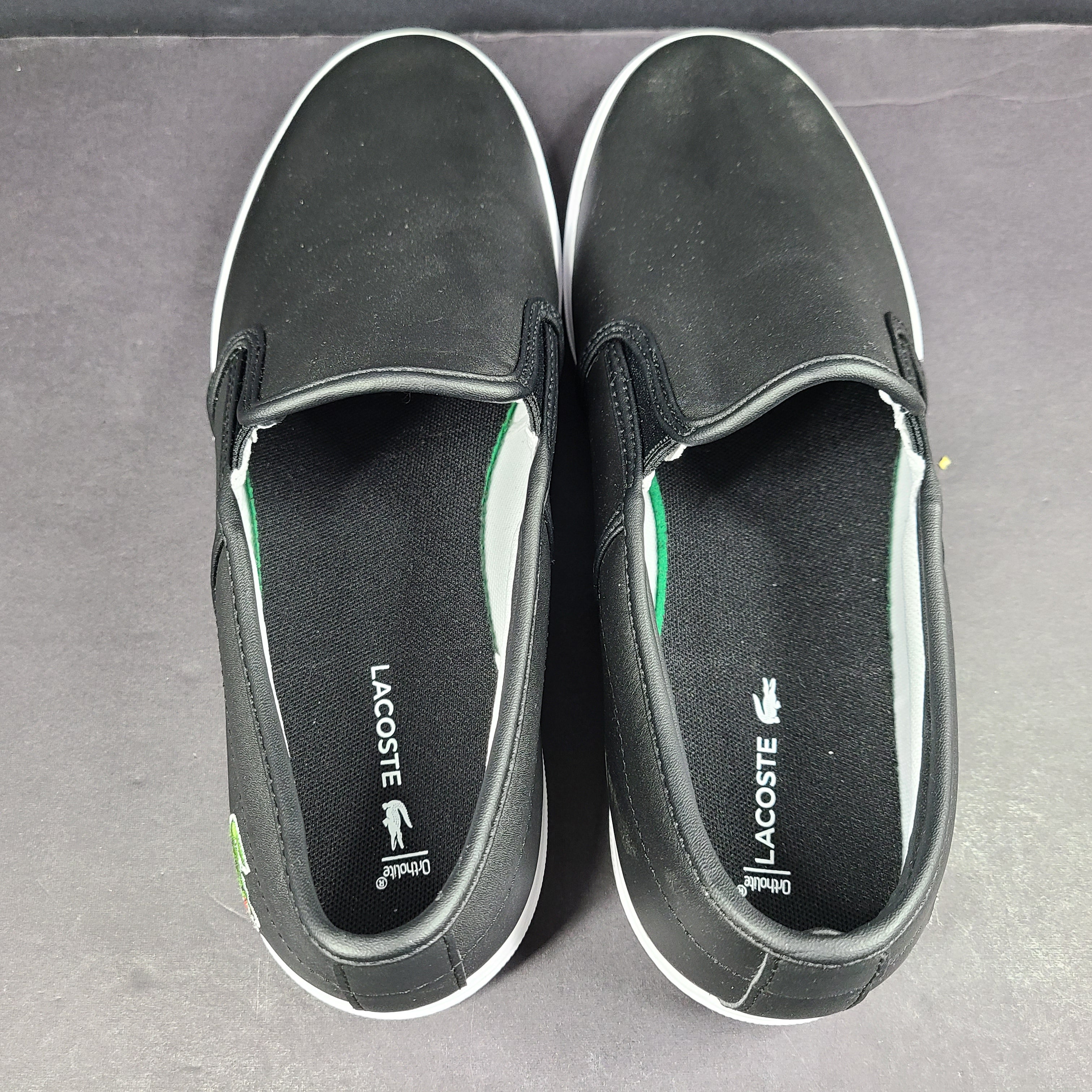 A pair of leather slip-on sneakers by Lacoste.