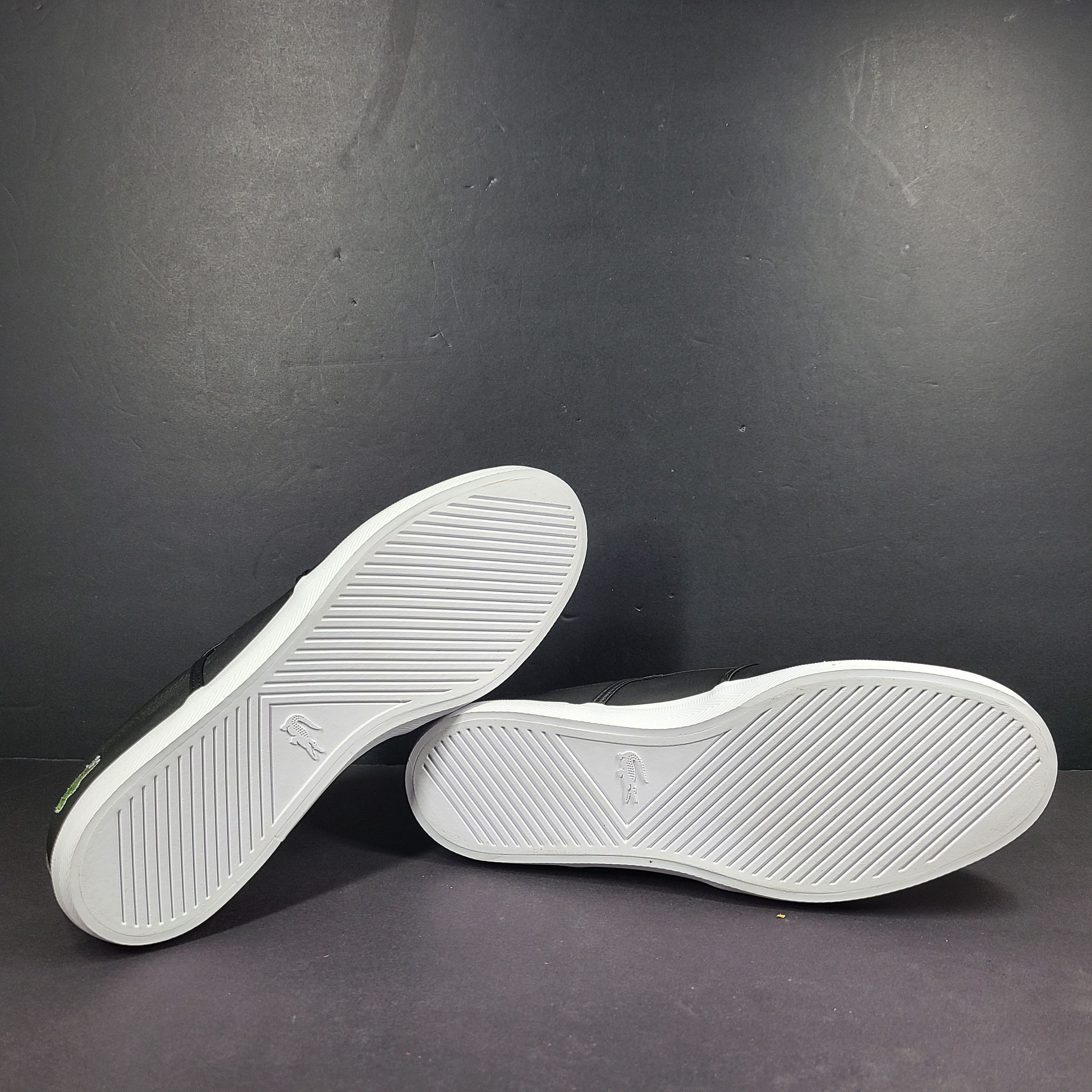 A pair of leather slip-on sneakers by Lacoste.