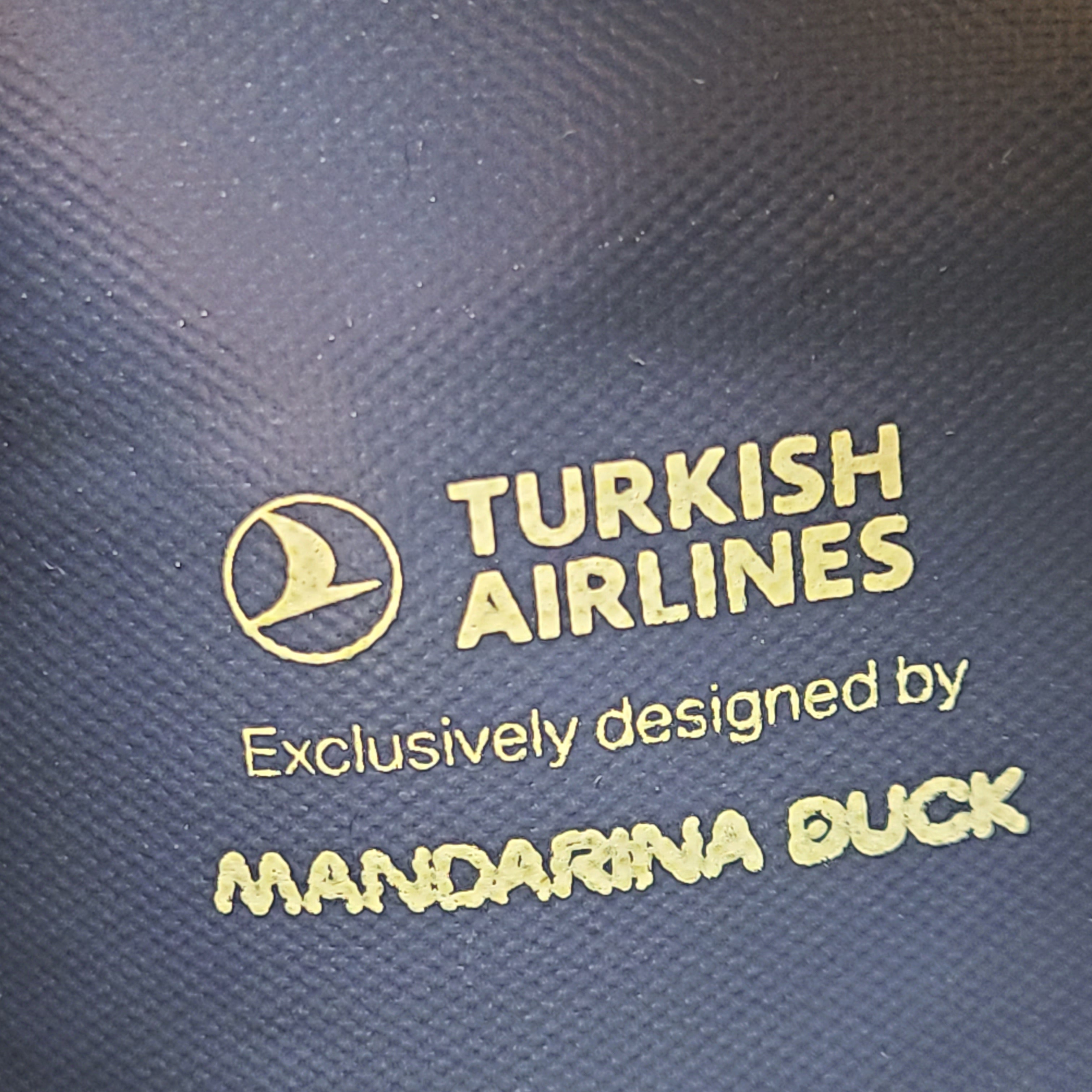 Sleek blue-gray Mandarina Duck Turkish Airlines travel kit pouch with socks, slippers, eye mask and an extra bag for compact organization.