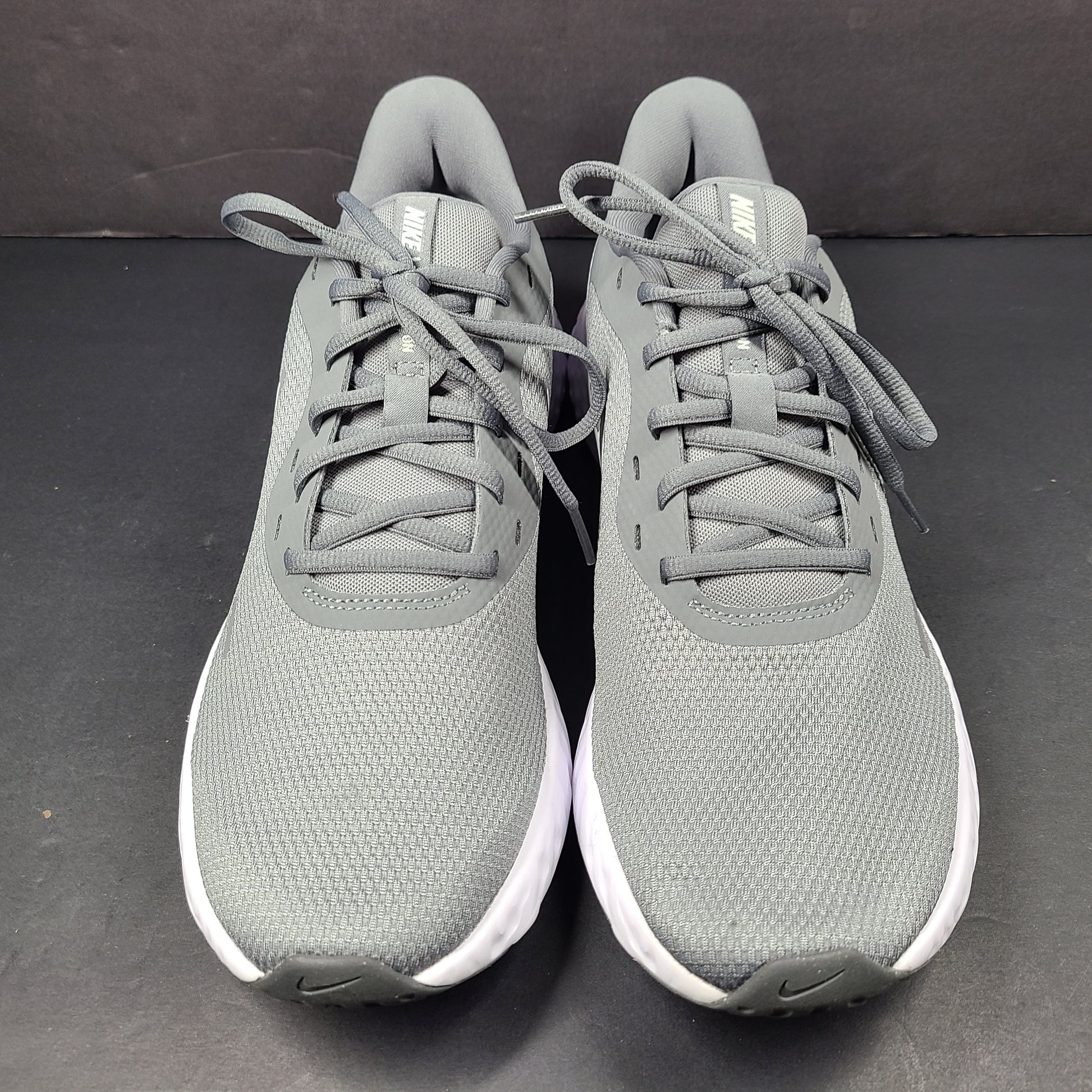 A pair of Nike Revolution 5 Men's Running Shoes in grey and white.