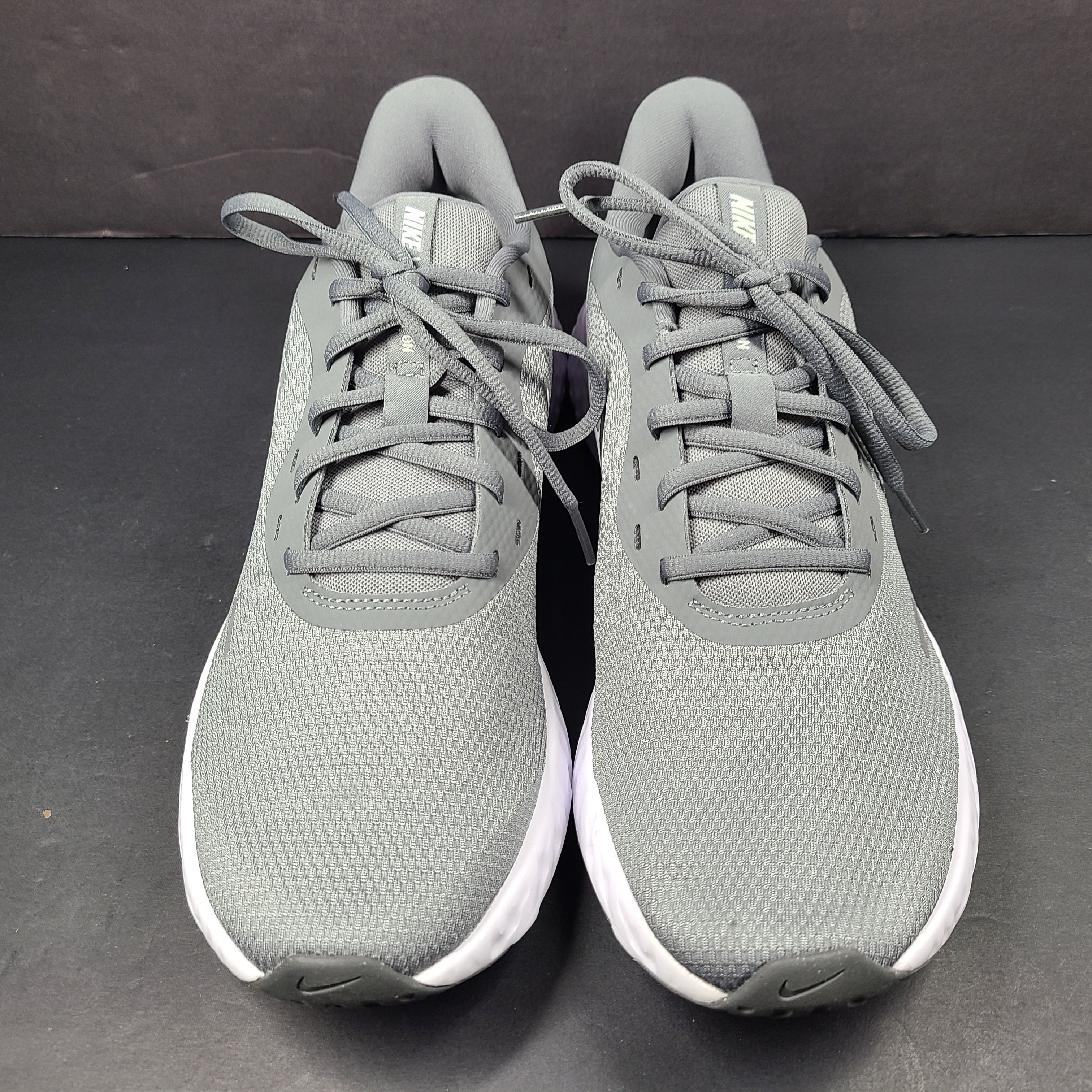 A pair of Nike Revolution 5 Men's Running Shoes in grey and white.