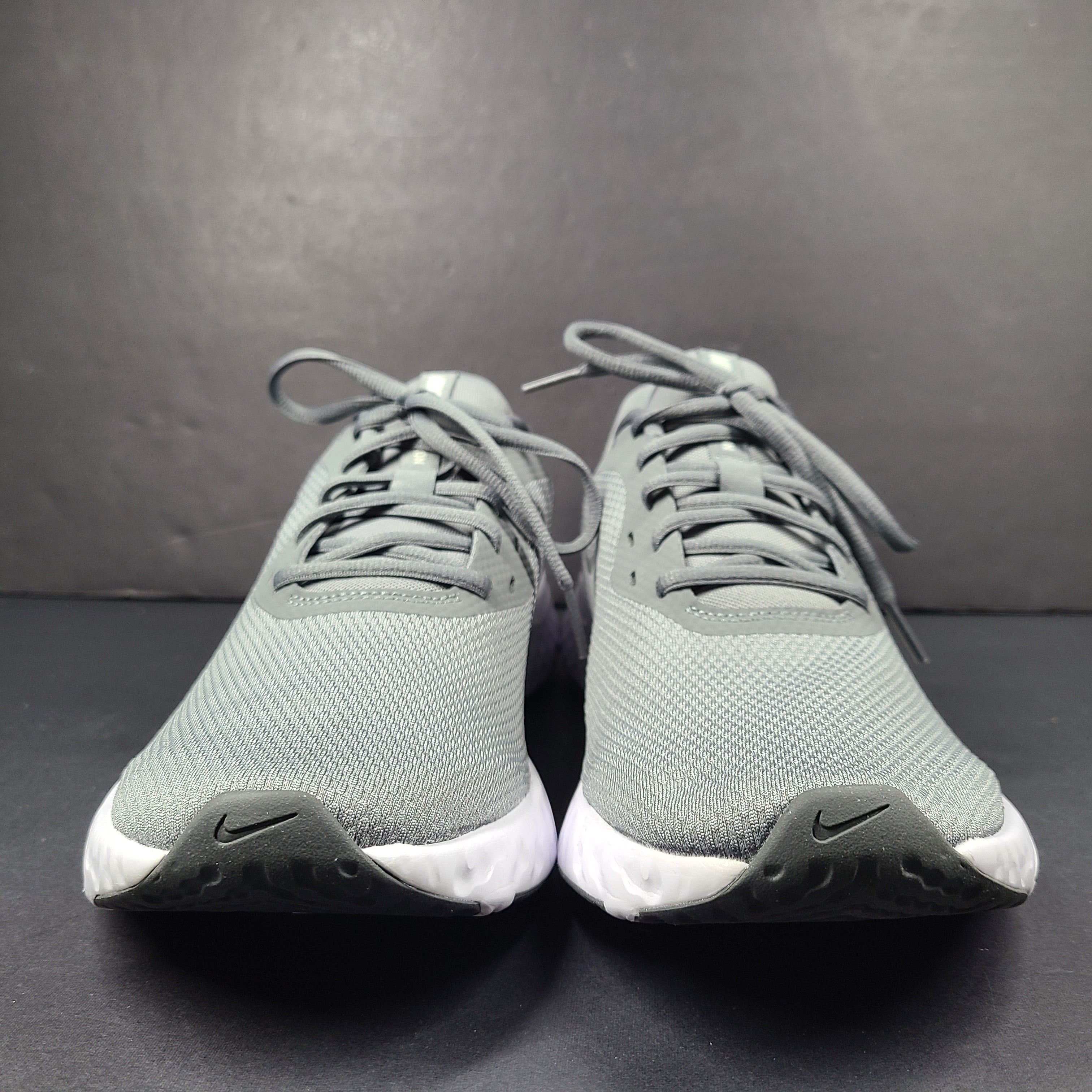 A pair of Nike Revolution 5 Men's Running Shoes in grey and white.