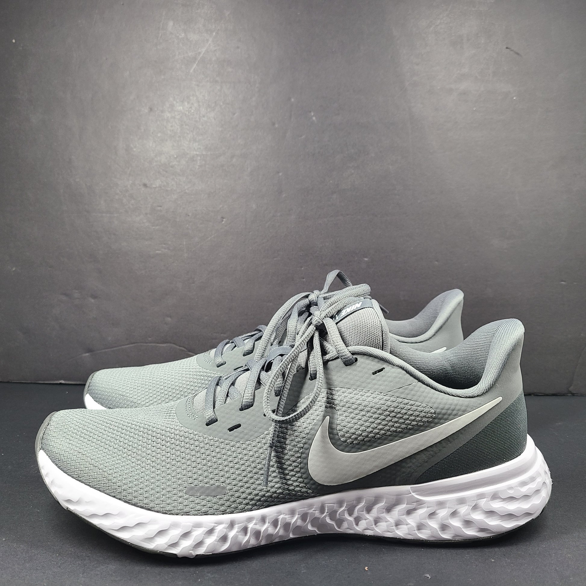 A pair of Nike Revolution 5 Men's Running Shoes in grey and white.