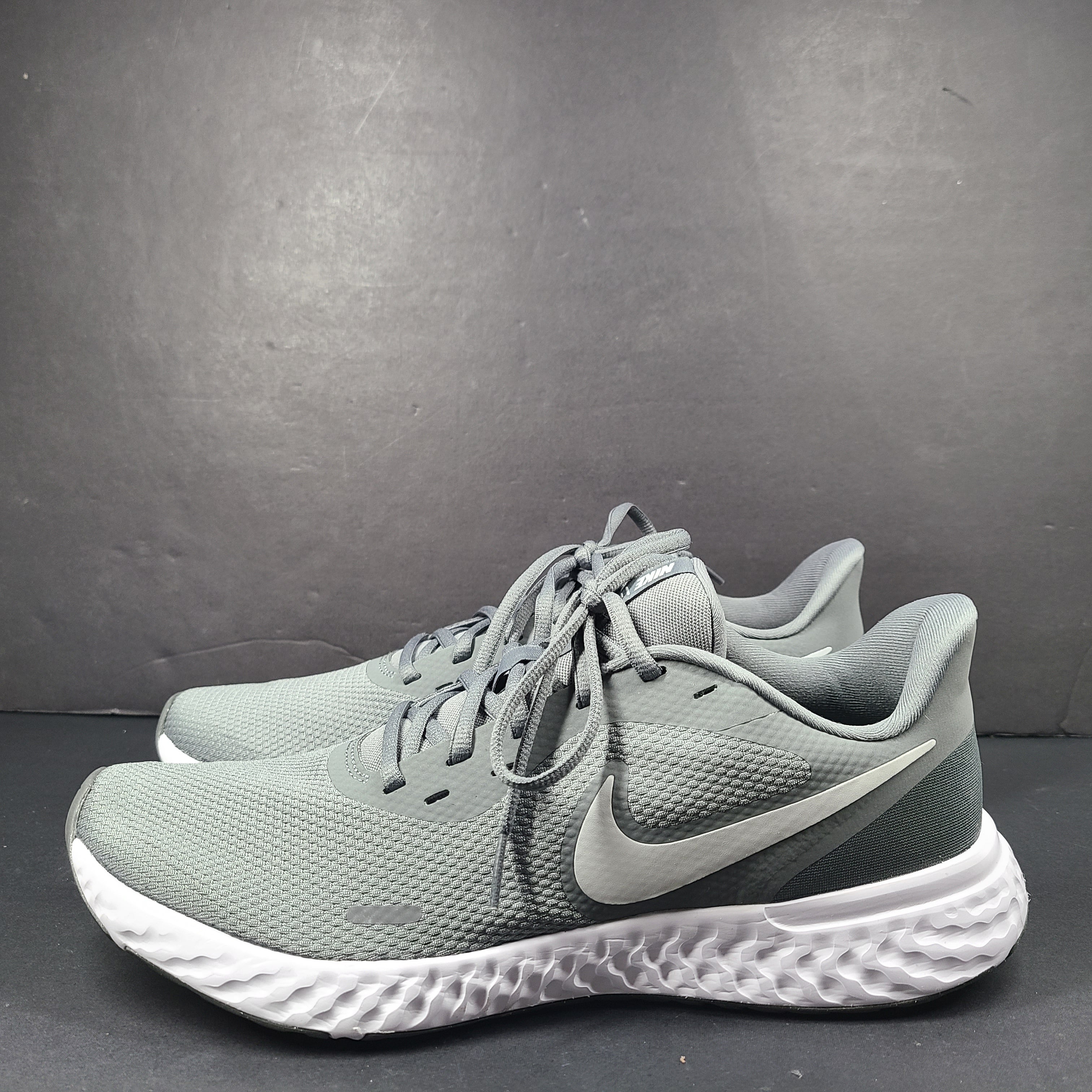 A pair of Nike Revolution 5 Men's Running Shoes in grey and white.