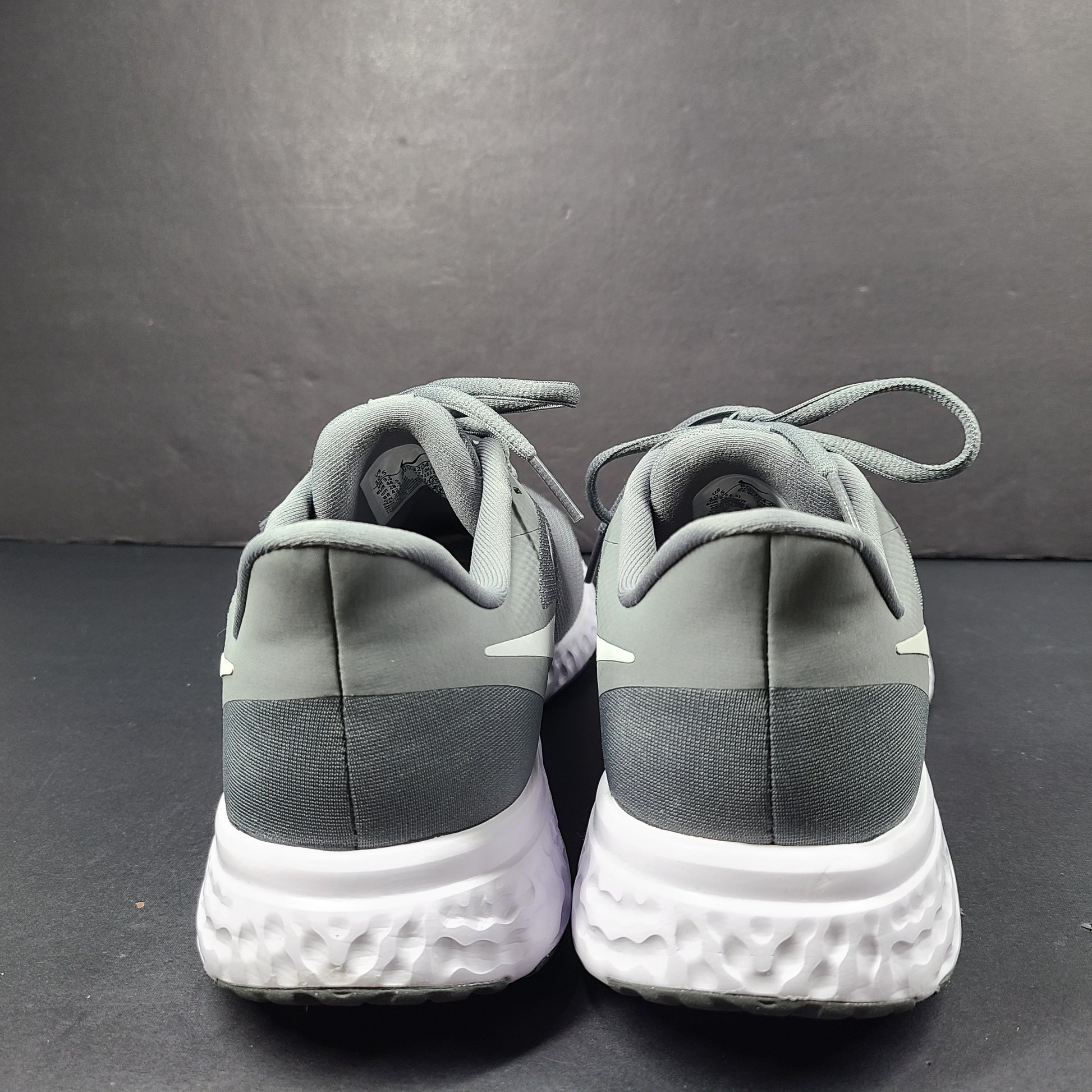 A pair of Nike Revolution 5 Men's Running Shoes in grey and white.