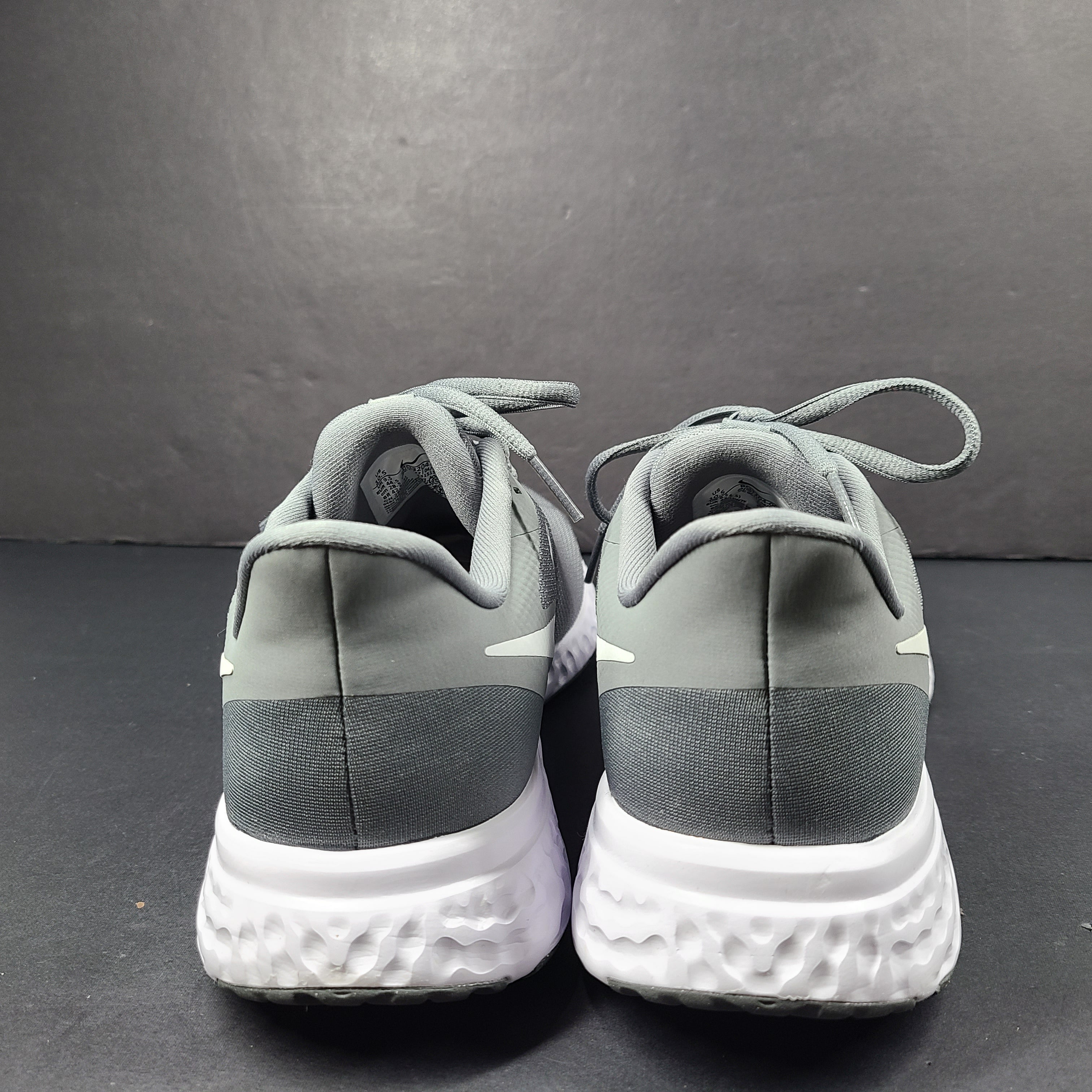 A pair of Nike Revolution 5 Men's Running Shoes in grey and white.