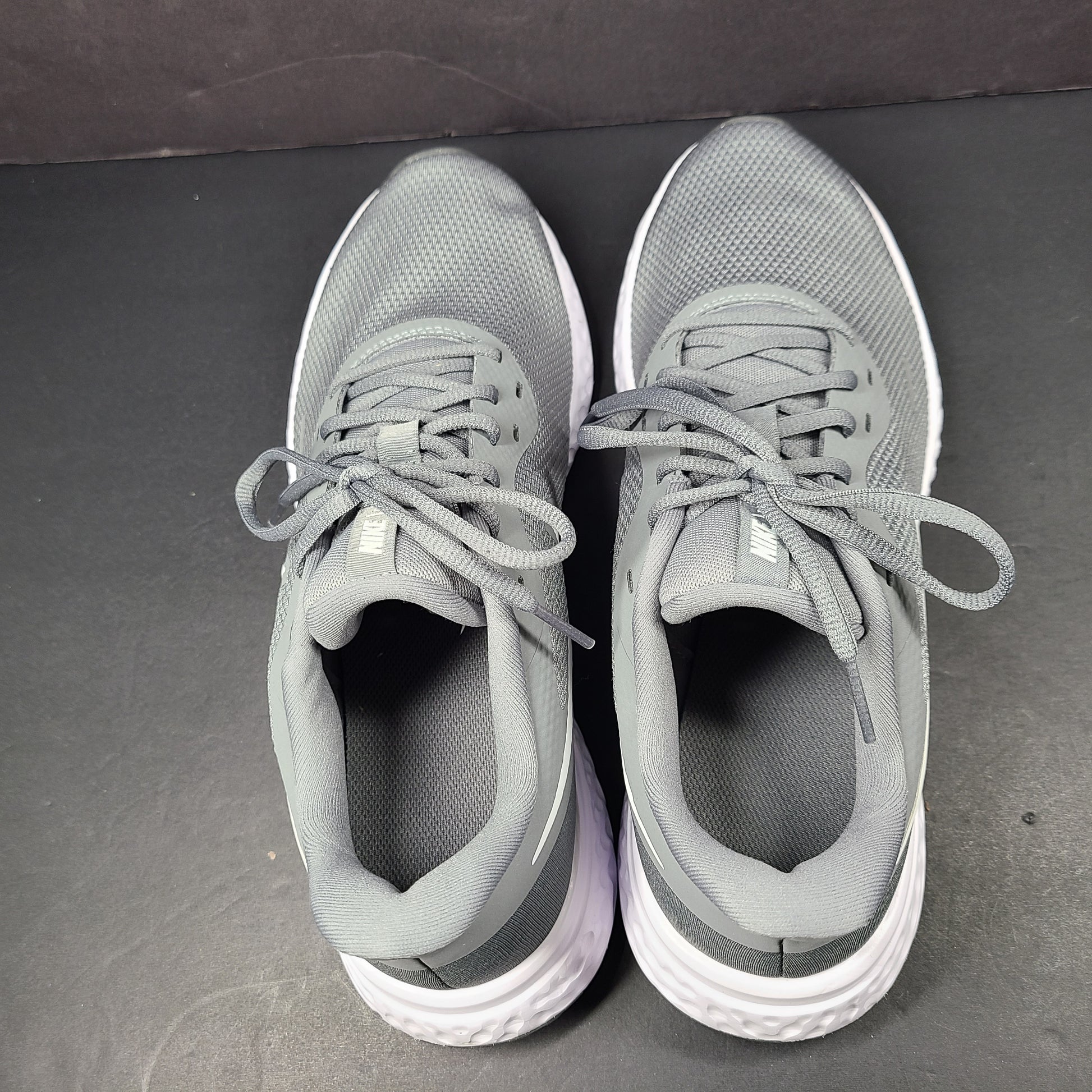 A pair of Nike Revolution 5 Men's Running Shoes in grey and white.