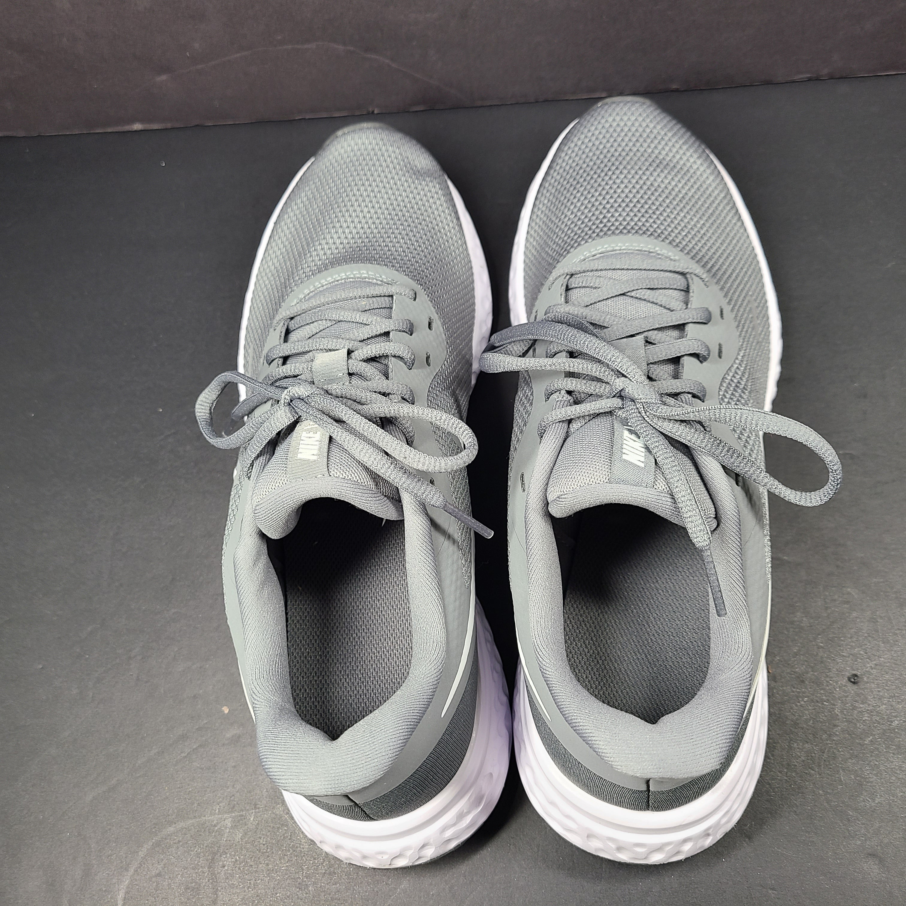 A pair of Nike Revolution 5 Men's Running Shoes in grey and white.