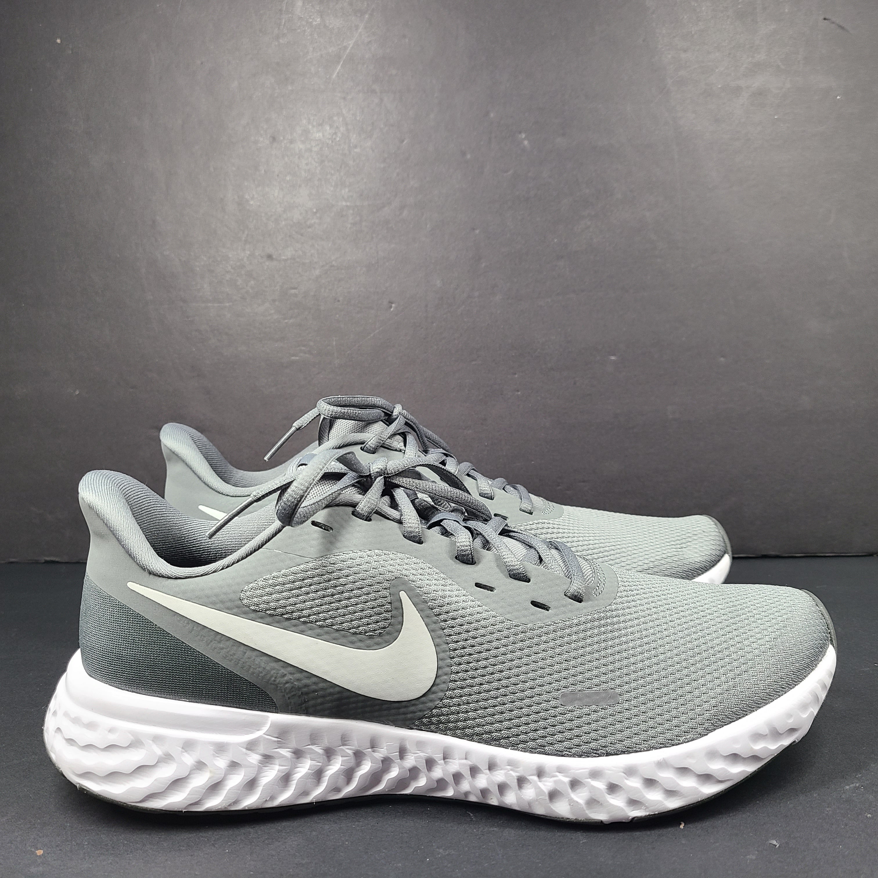 A pair of Nike Revolution 5 Men's Running Shoes in grey and white.