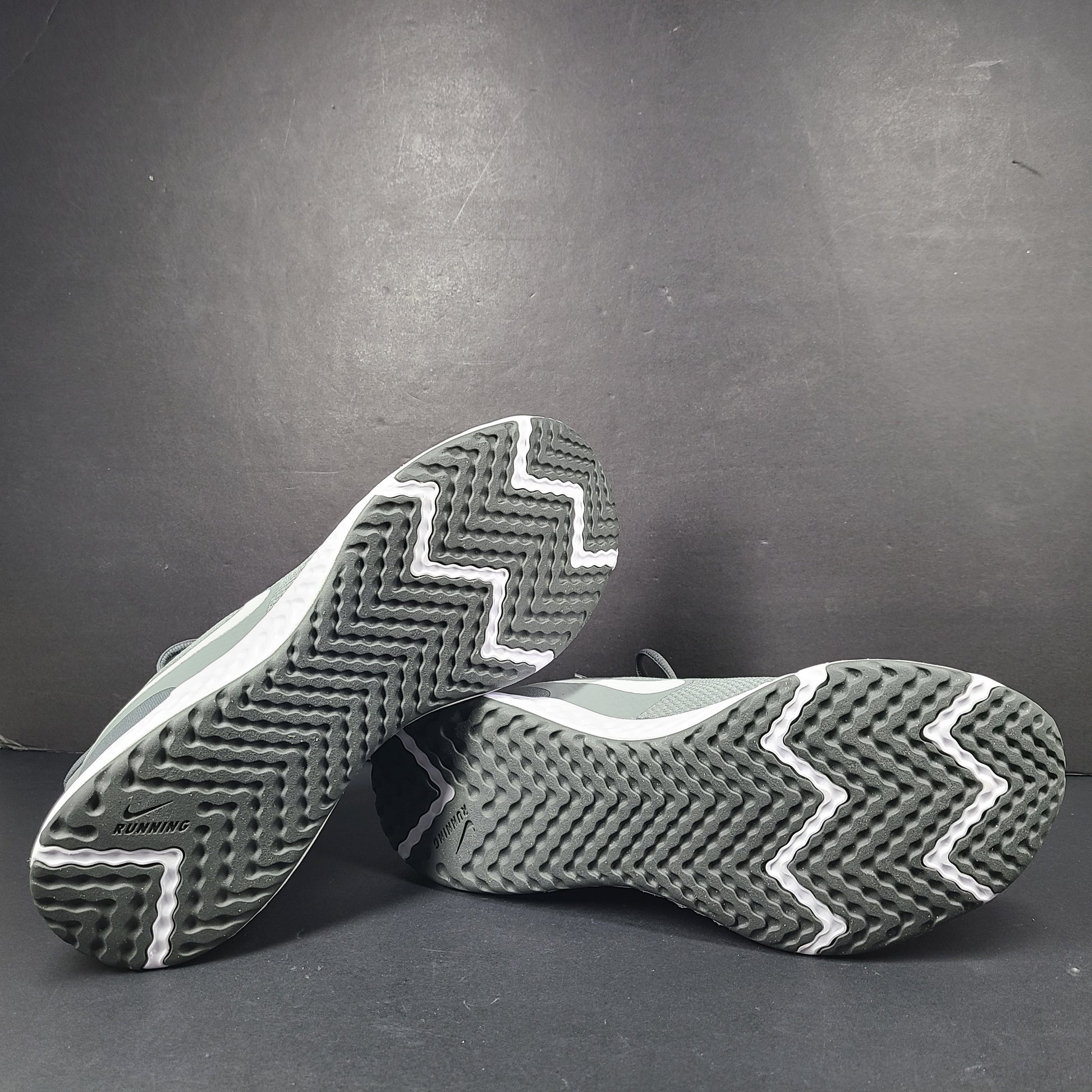 A pair of Nike Revolution 5 Men's Running Shoes in grey and white.