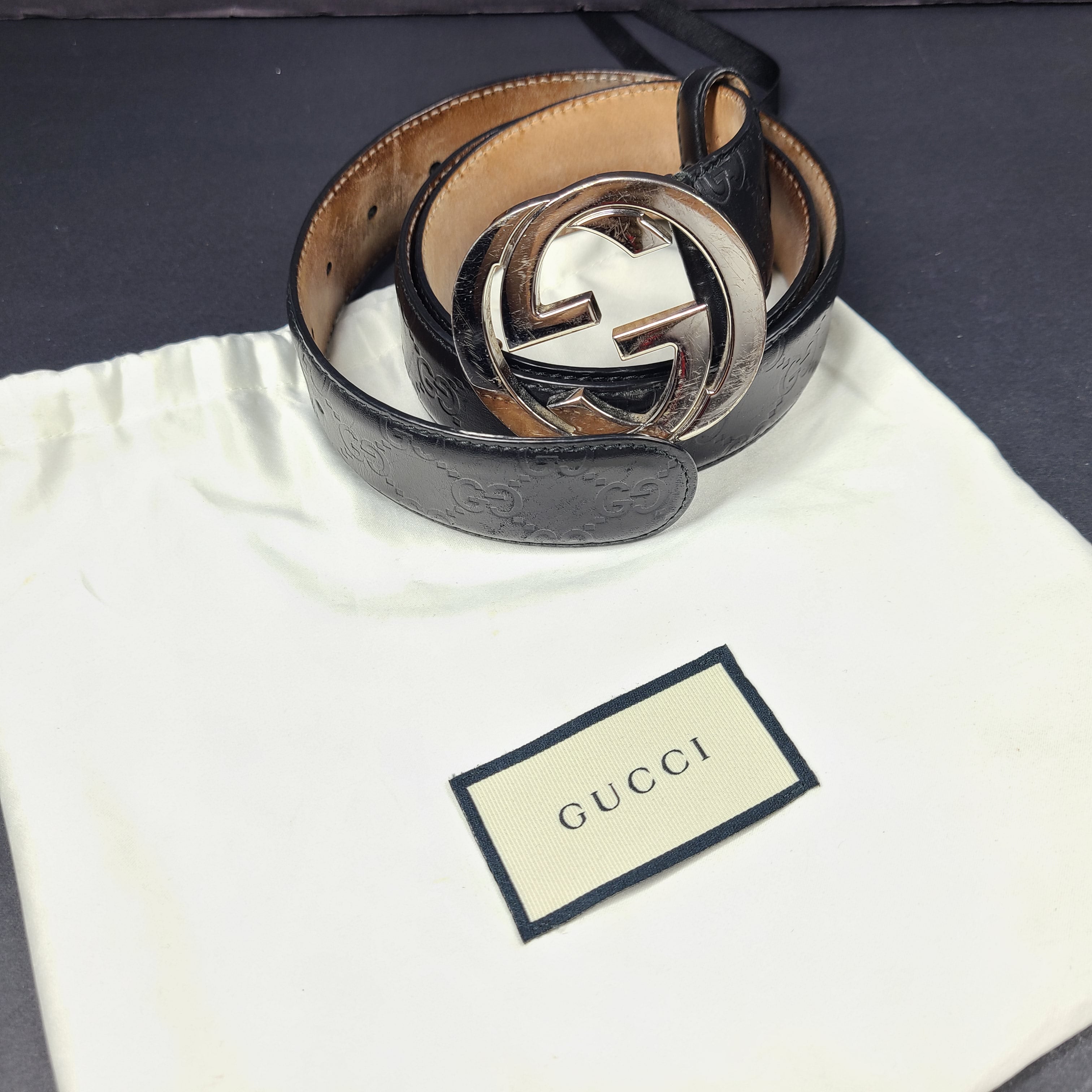 Black Gucci leather belt with interlocking G buckle and a slim, refined profile.