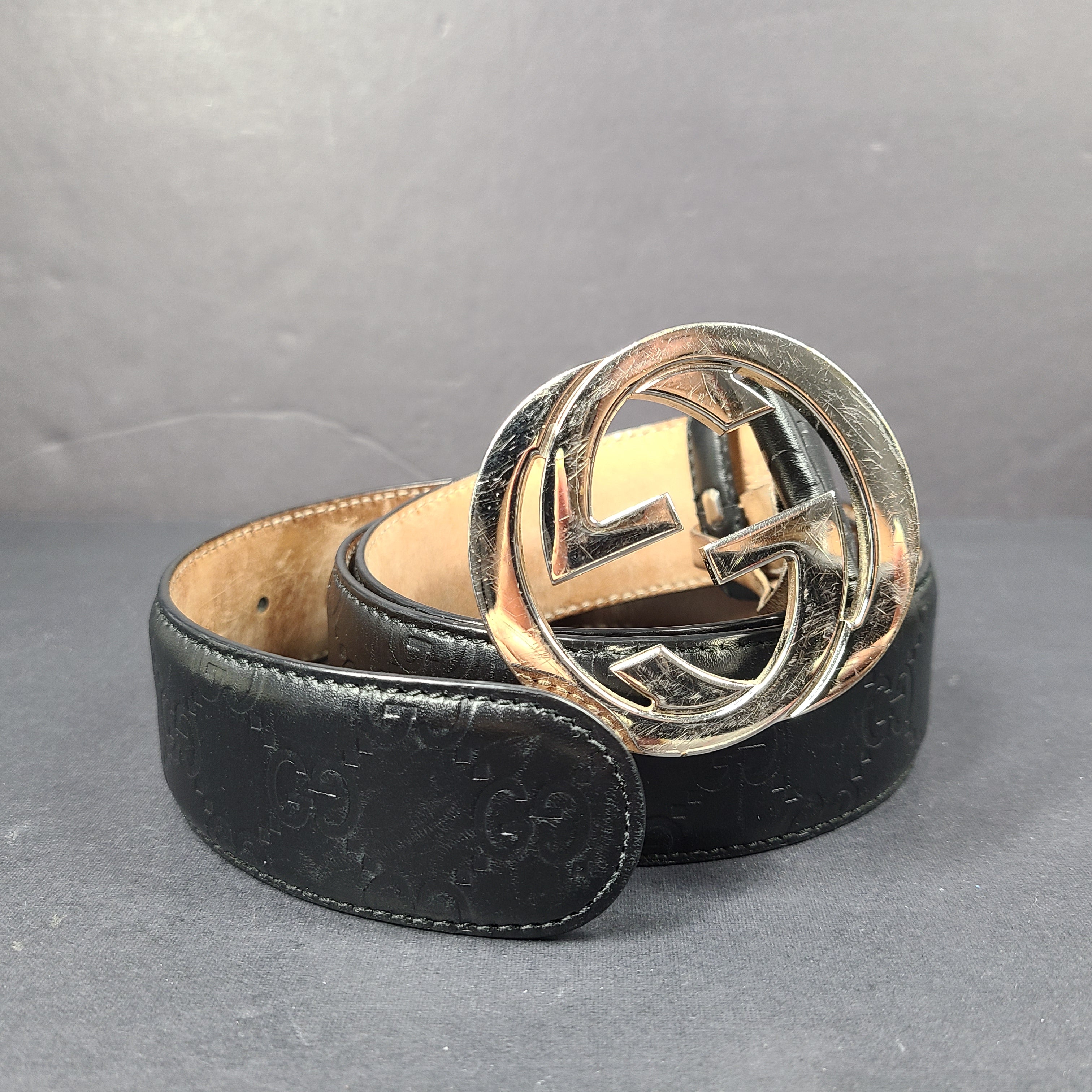 Black Gucci leather belt with interlocking G buckle and a slim, refined profile.