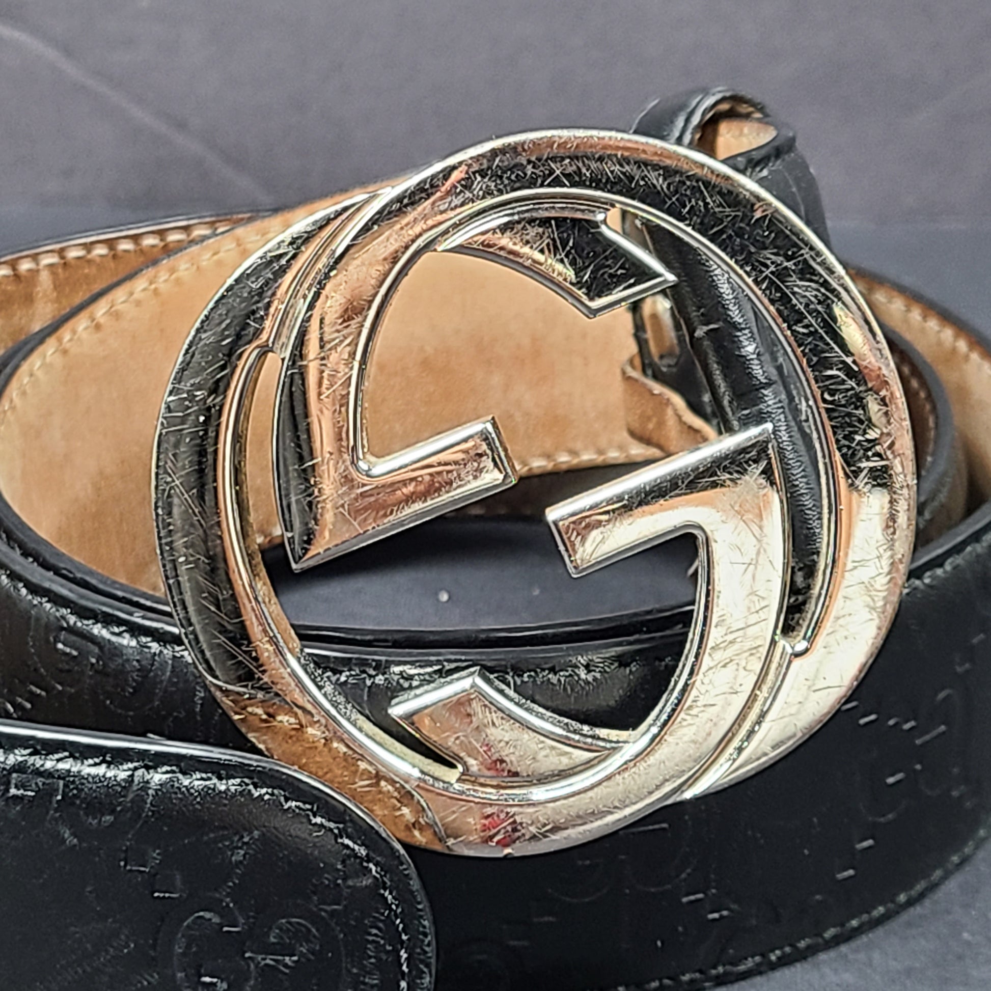 Black Gucci leather belt with interlocking G buckle and a slim, refined profile.