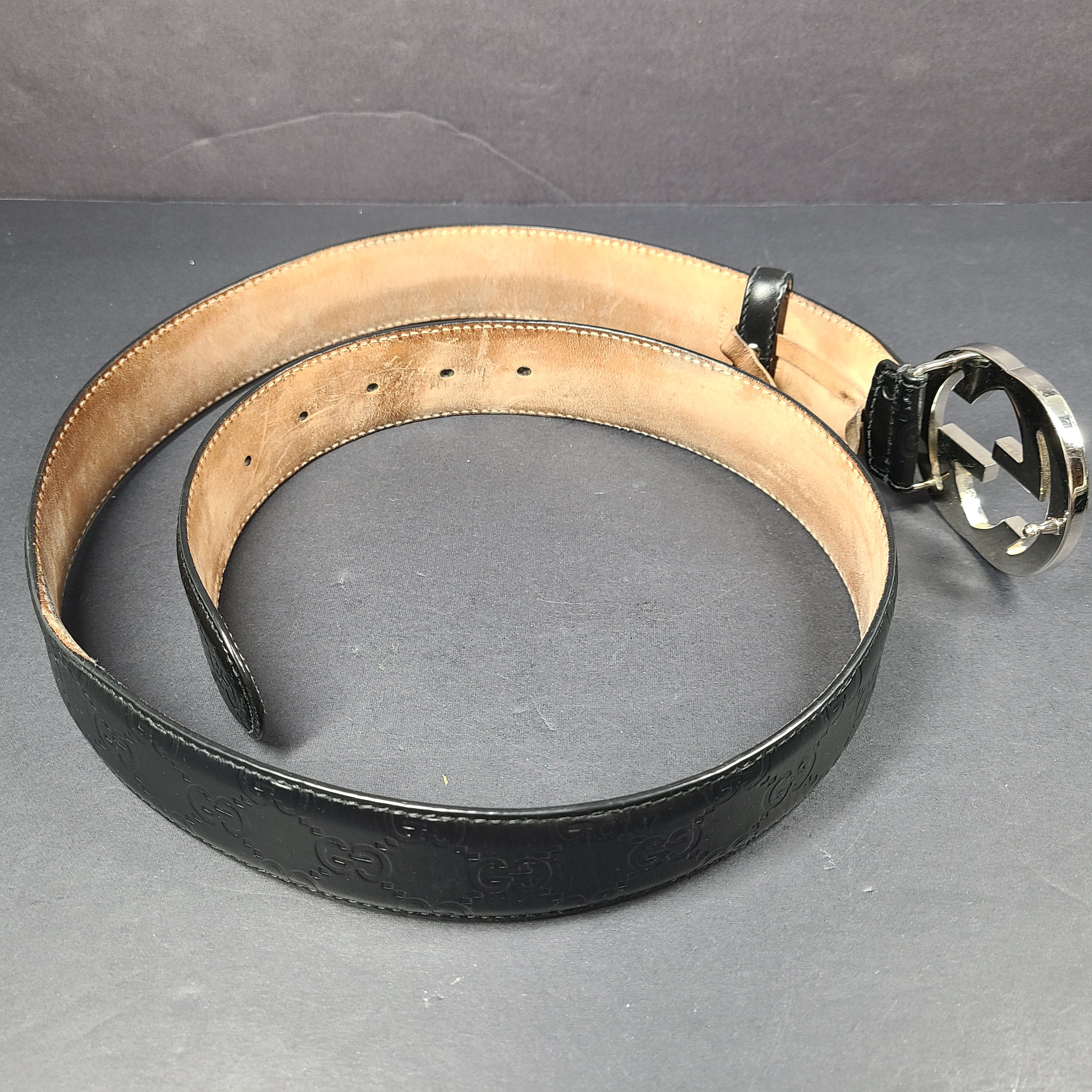 Black Gucci leather belt with interlocking G buckle and a slim, refined profile.