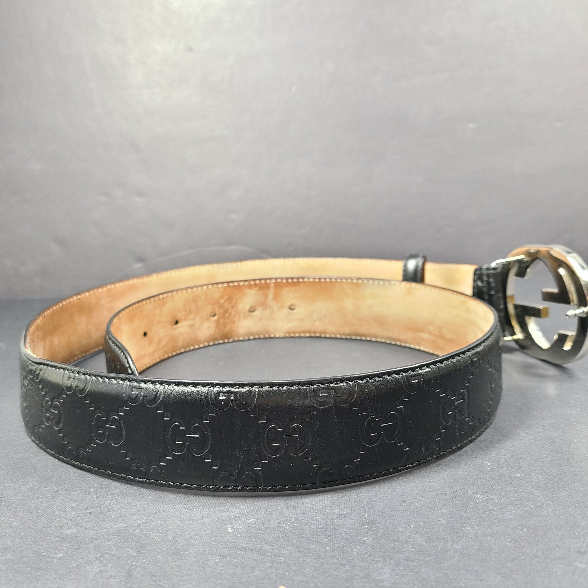 Black Gucci leather belt with interlocking G buckle and a slim, refined profile.