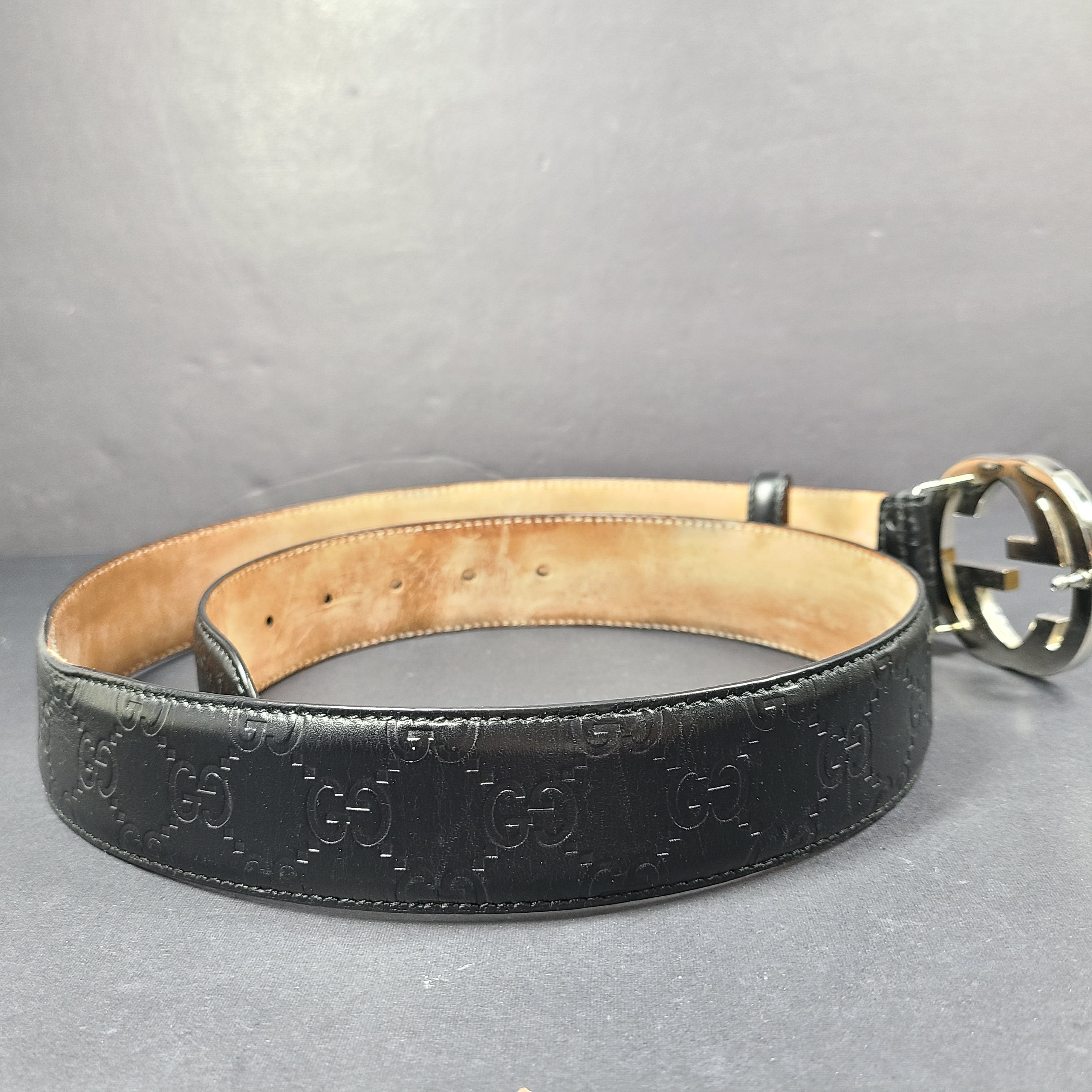 Black Gucci leather belt with interlocking G buckle and a slim, refined profile.