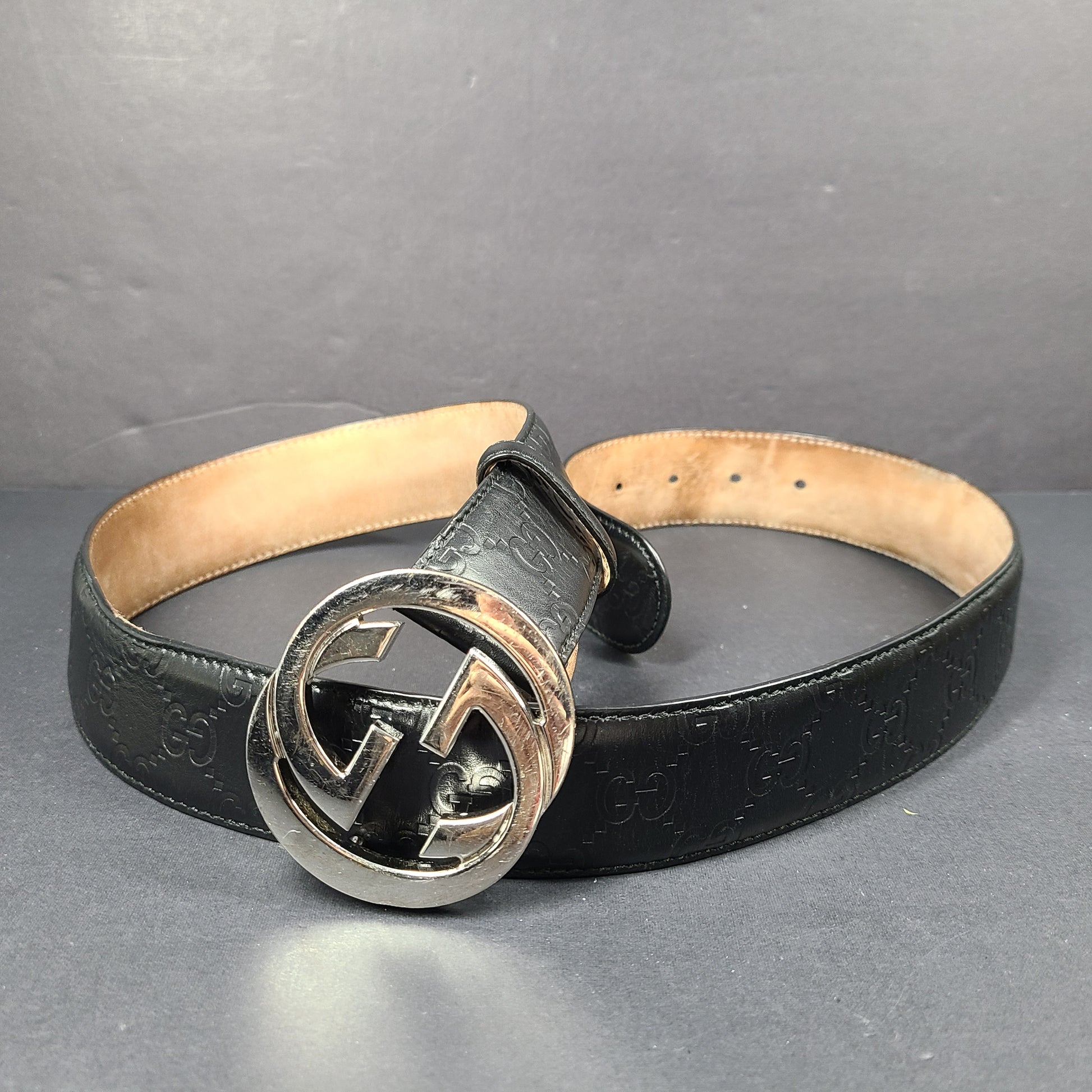 Black Gucci leather belt with interlocking G buckle and a slim, refined profile.