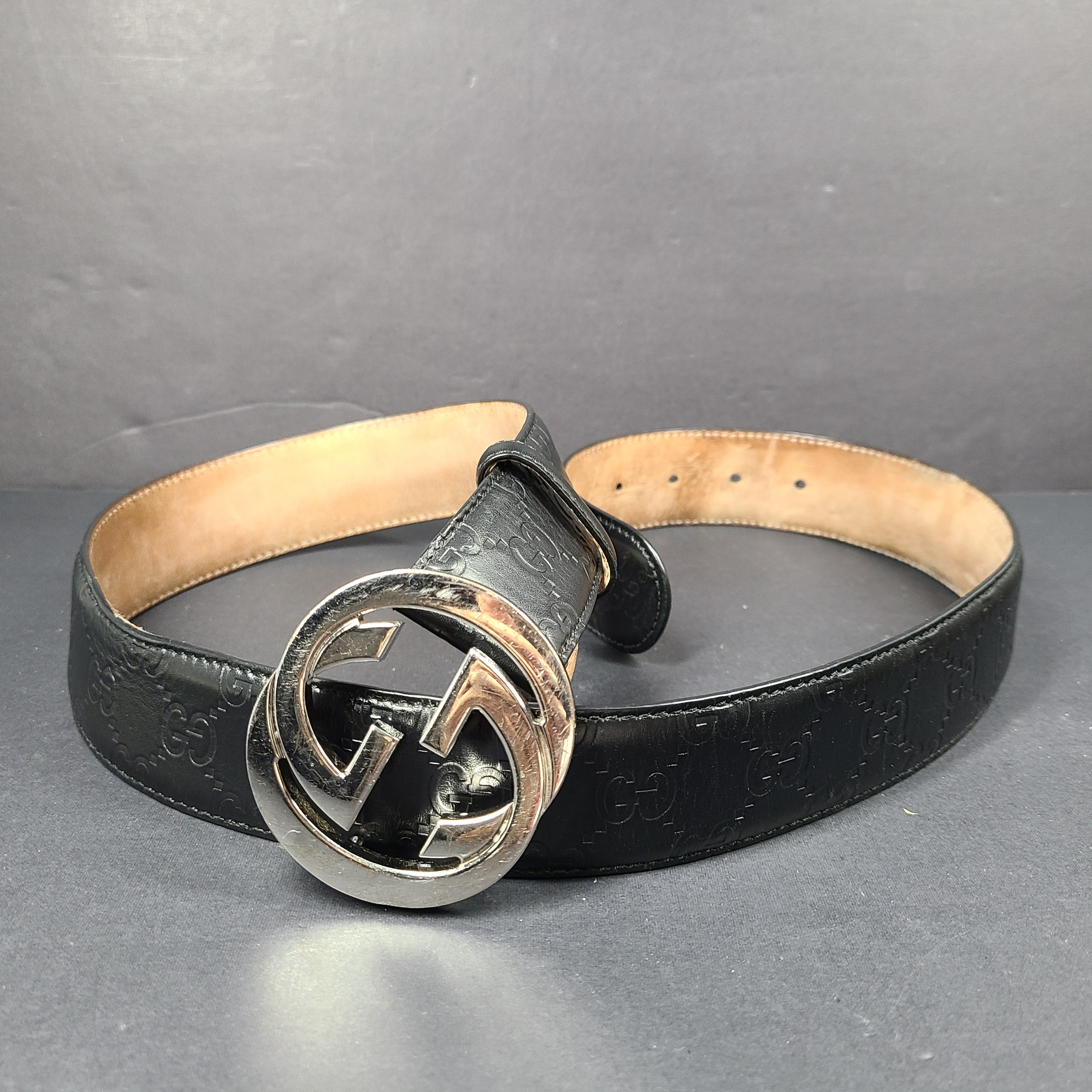 Black Gucci leather belt with interlocking G buckle and a slim, refined profile.