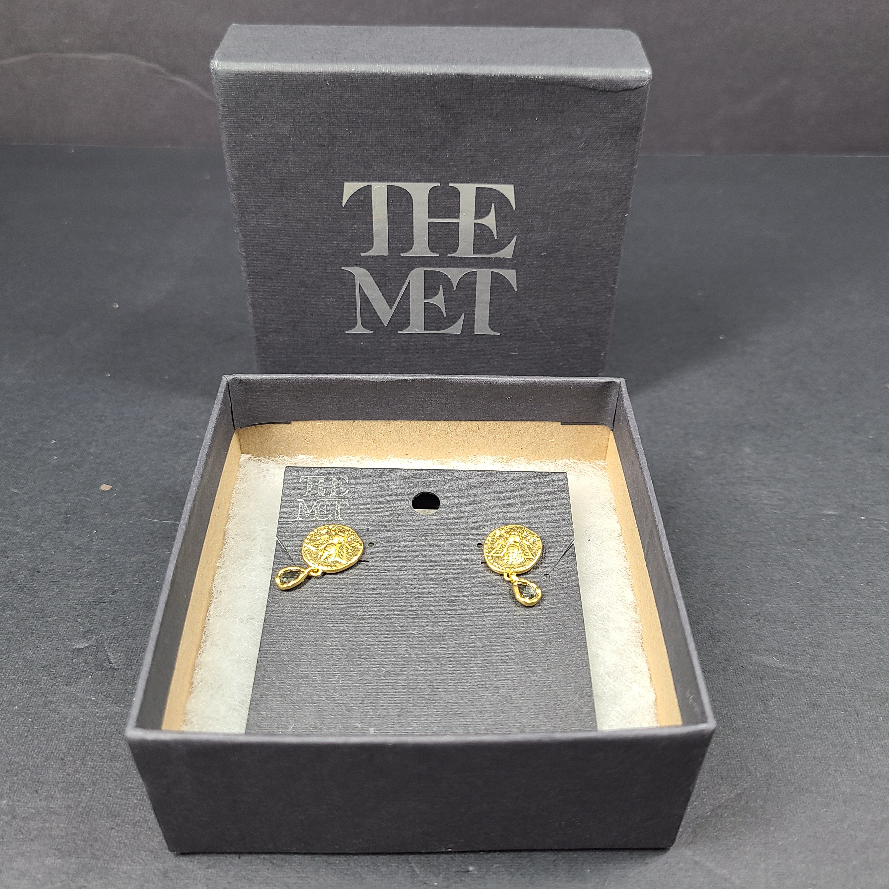 Gold Mediterranean coin stud earrings with secure posts and a timeless classical motif for everyday and evening wear.