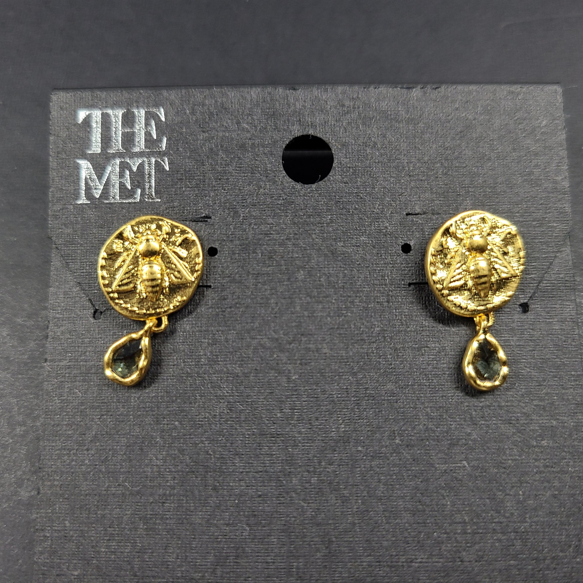 Gold Mediterranean coin stud earrings with secure posts and a timeless classical motif for everyday and evening wear.