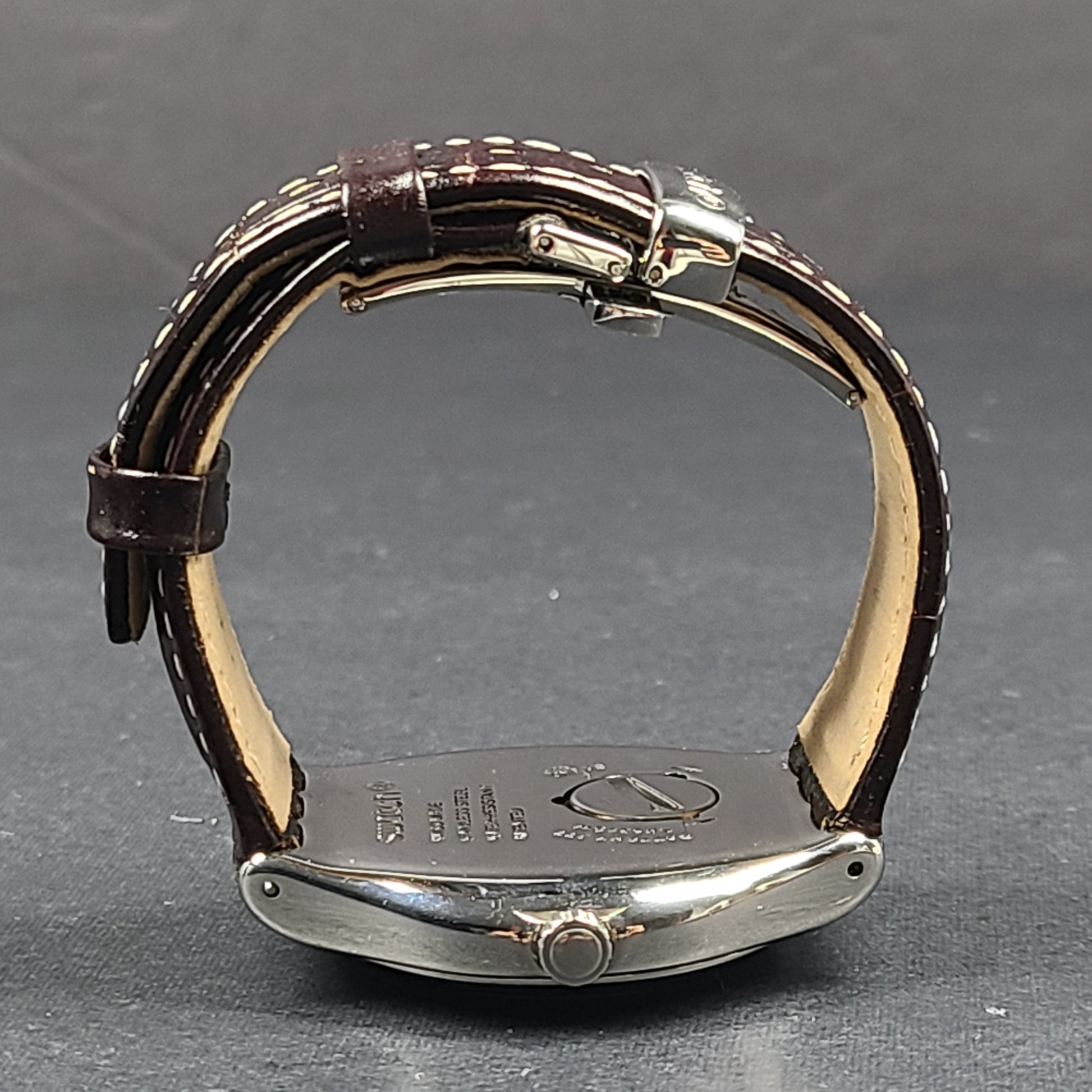 Swatch YGS452G stainless steel wristwatch with a white dial and brown leather strap.