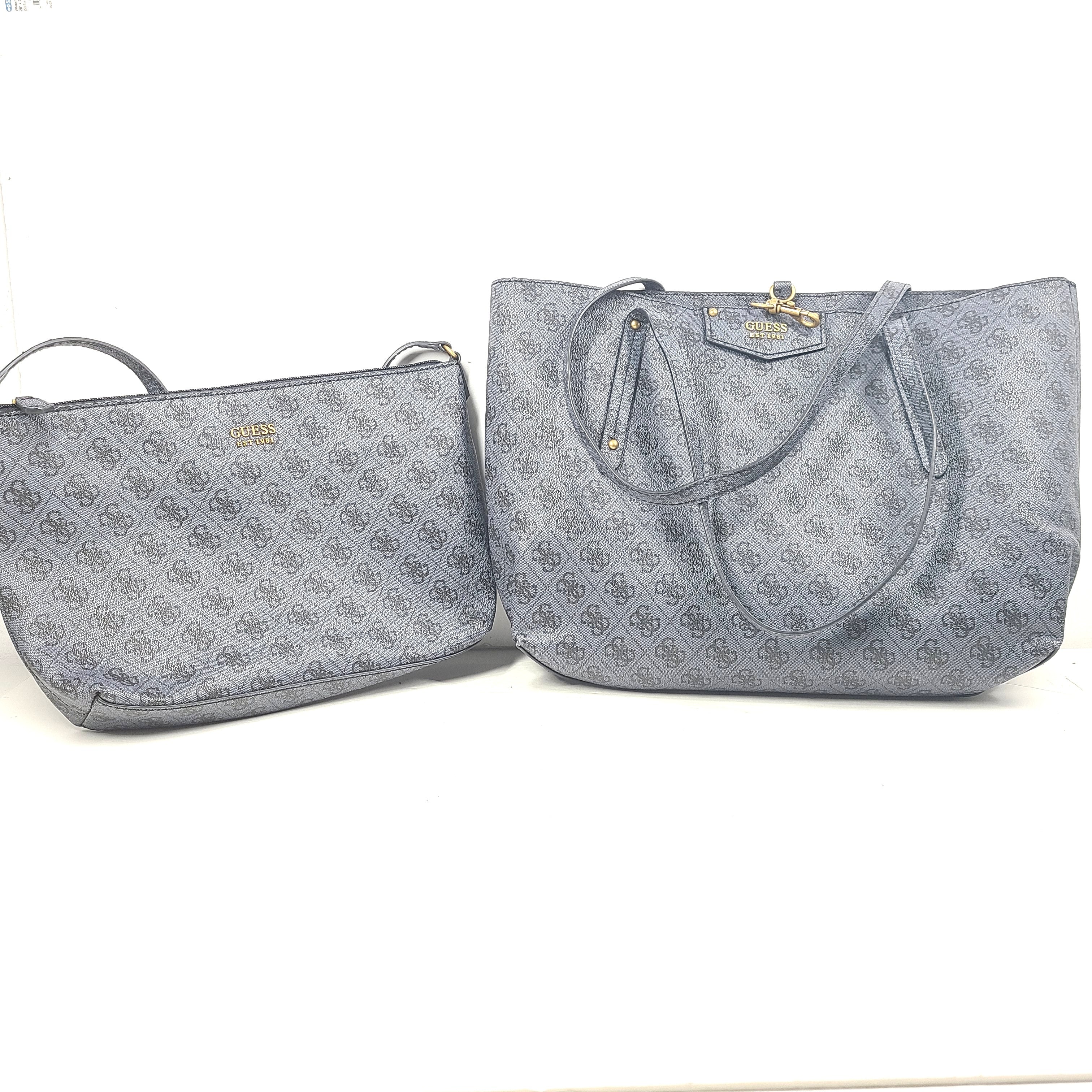 Grey GUESS monogram tote with gold-tone hardware and a matching pouch for organized everyday carry.