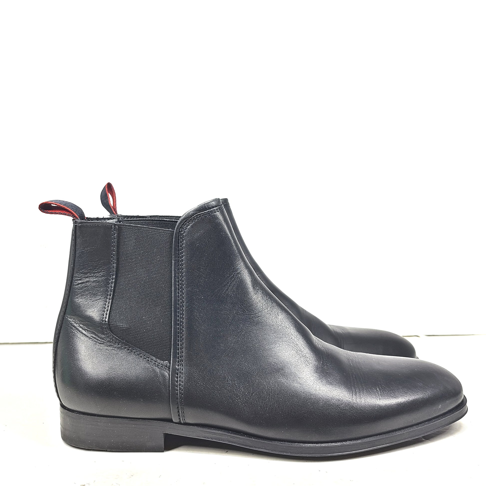 Black leather Chelsea boots by Hugo Boss with a sleek ankle silhouette and branded insole.